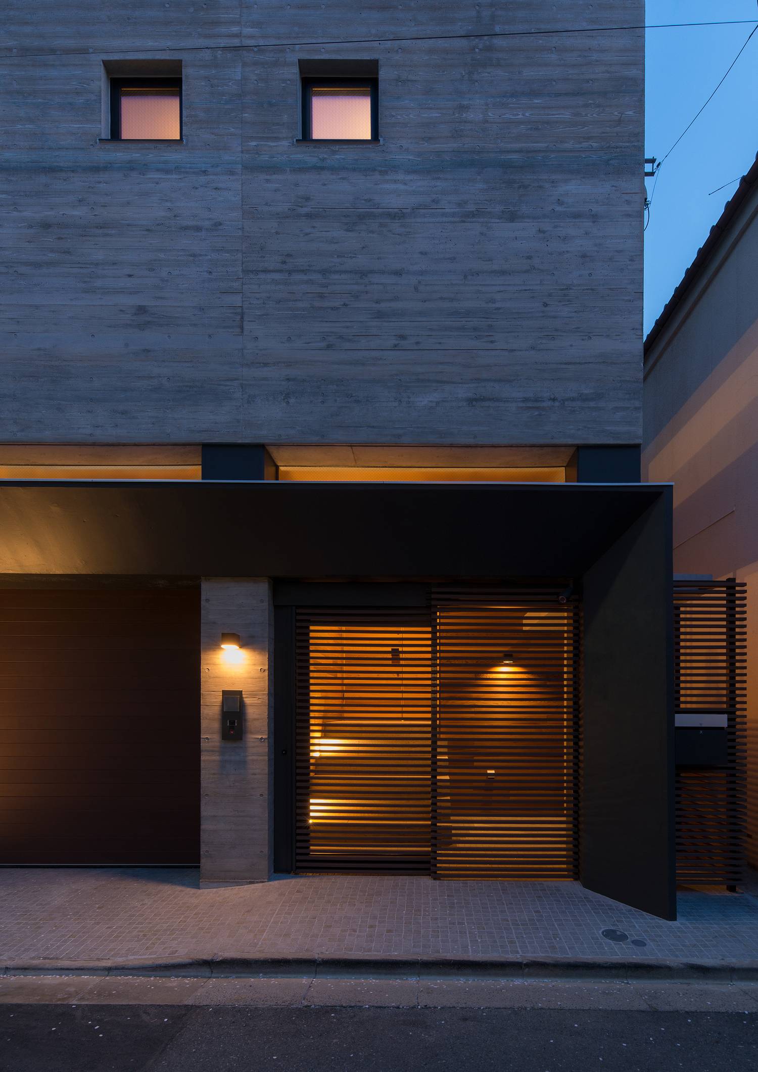 ルーバーの引き戸の玄関扉がある、コンクリート打ち放しの外壁の住まい・デザイン住宅 注文住宅・デザイン住宅建築実例_『CASE606 CEDAR BOX』_玄関