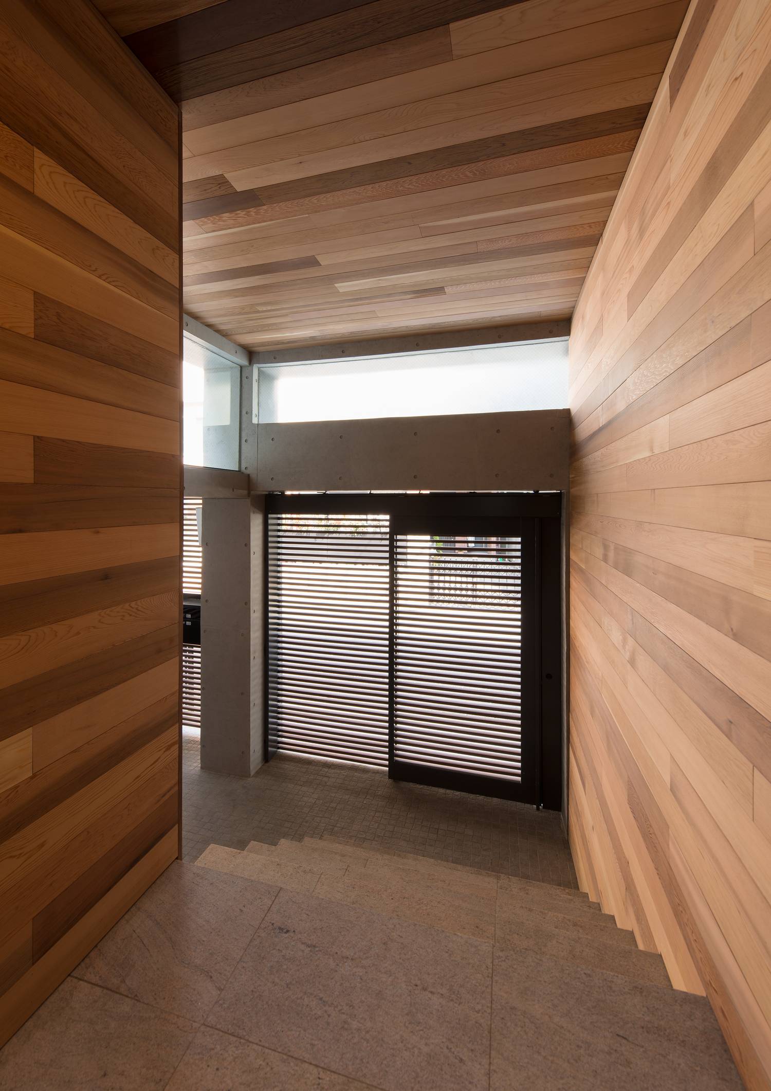 木の壁に囲まれた、扉の上にスリット窓がある玄関・デザイン住宅 注文住宅・デザイン住宅建築実例_『CASE606 CEDAR BOX』_玄関