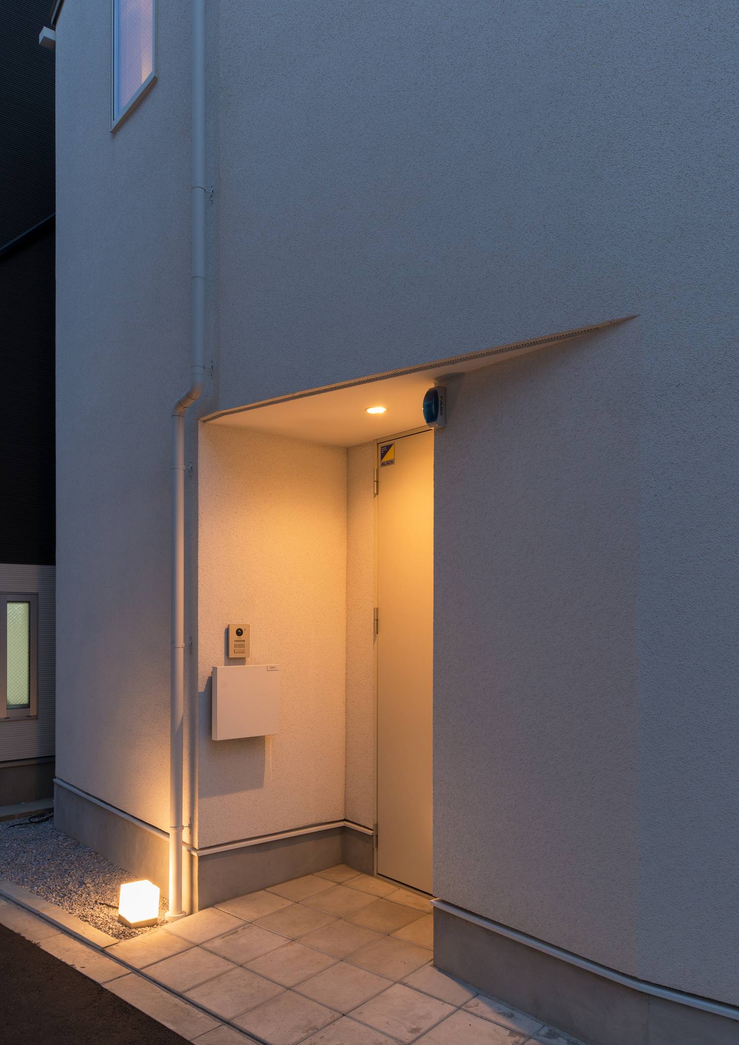 足元の間接照明や軒天井のダウンライトに照らされた白い扉の玄関・デザイン住宅 注文住宅・デザイン住宅建築実例_『CASE628 つみ木』_玄関