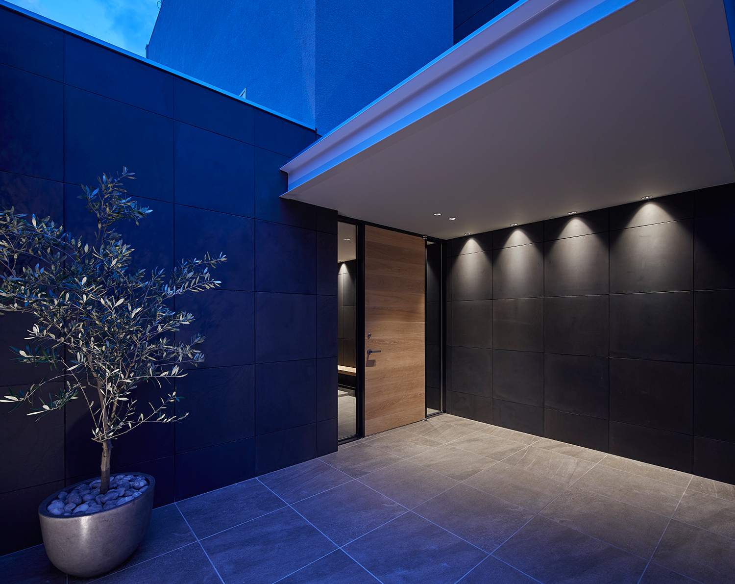 天井の壁際にダウンライトを取り付けた木の玄関扉があるエントランス・デザイン住宅 注文住宅・デザイン住宅建築実例_『CASE632 H邸（社長の邸宅）』_外観