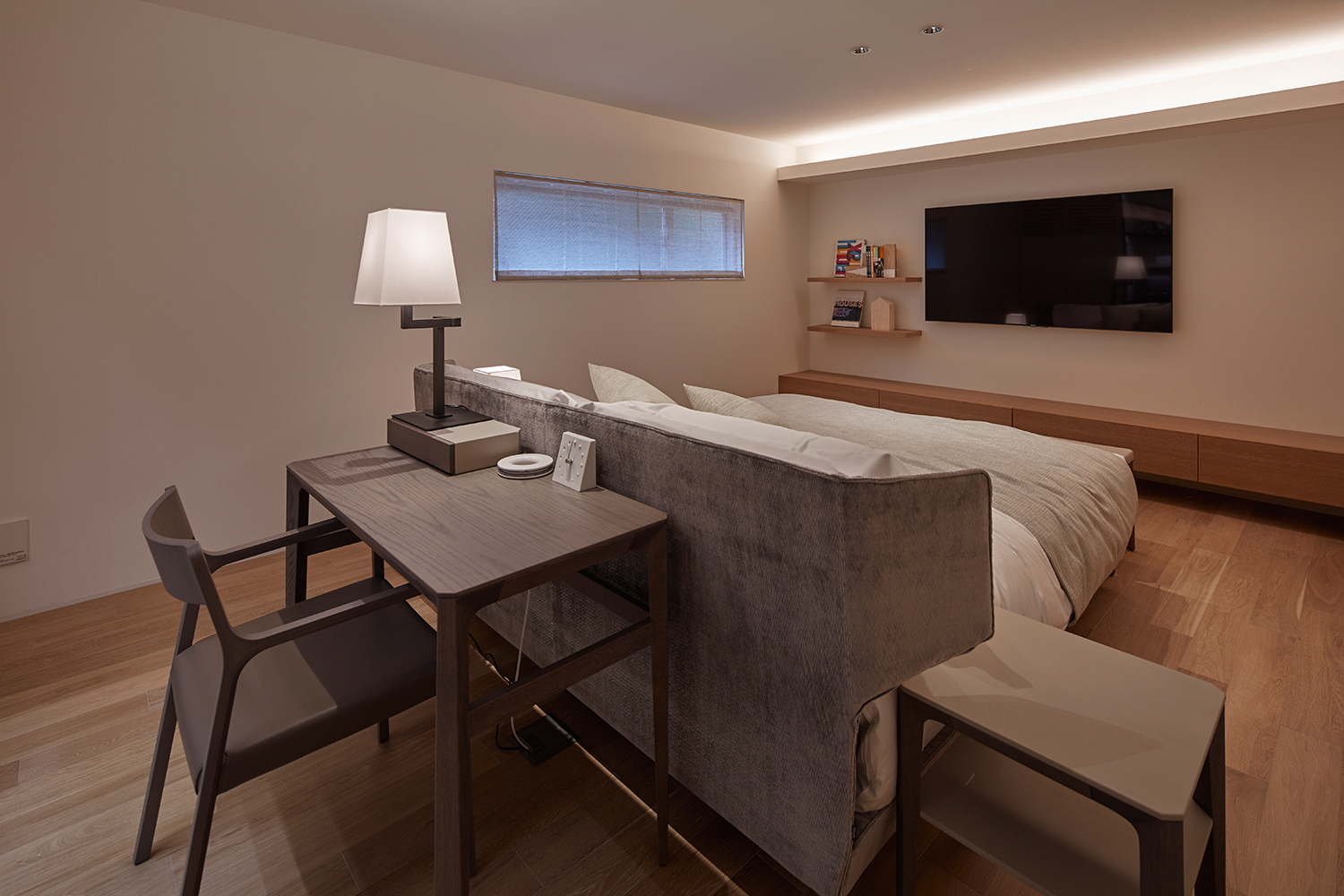 ベッドの正面にテレビを取り付け、壁際に間接照明を取り付けたスリット窓のある寝室・デザイン住宅 注文住宅・デザイン住宅建築実例_『CASE632 H邸（社長の邸宅）』_寝室