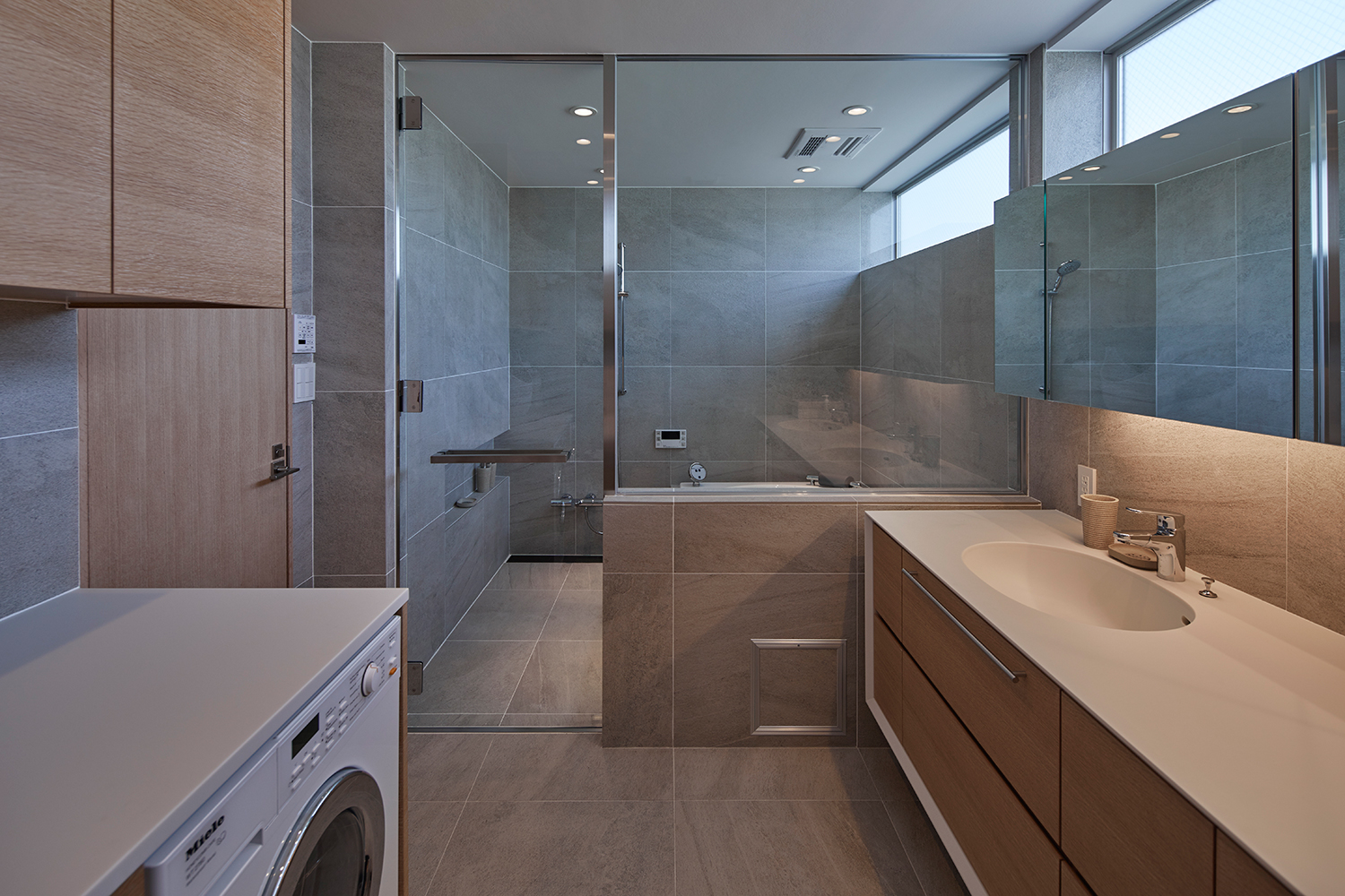 洗面所と浴室がガラスの窓とガラスの扉で仕切られている様子・デザイン住宅 注文住宅・デザイン住宅建築実例_『CASE632 H邸（社長の邸宅）』_浴室・洗面所