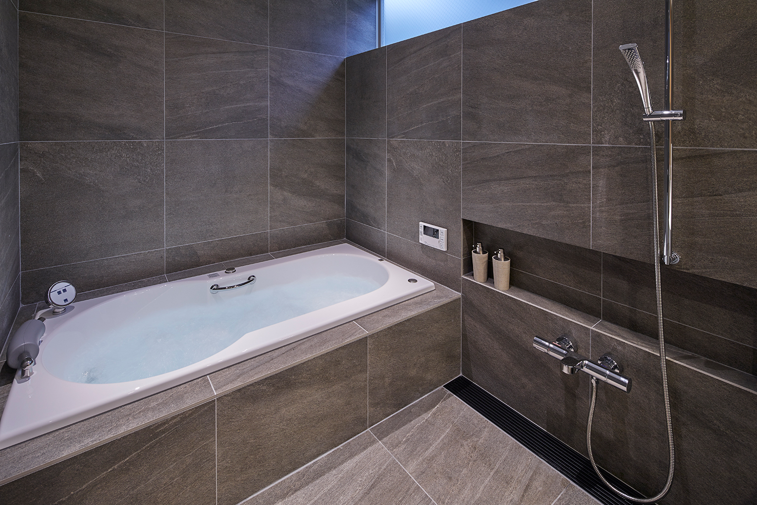 壁や床をグレーのタイルとしたユニットバス・デザイン住宅 注文住宅・デザイン住宅建築実例_『CASE632 H邸（社長の邸宅）』_浴室・洗面所