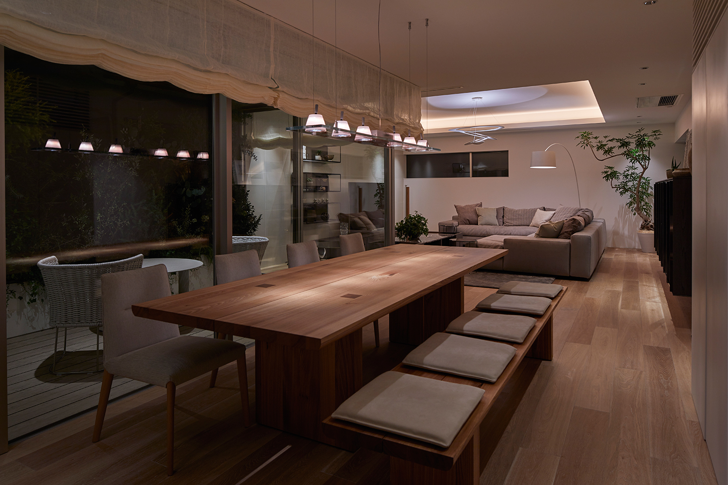 ペンダントライトに照らされた八人掛けの木製のダイニングテーブルがあるLDK・デザイン住宅 注文住宅・デザイン住宅建築実例_『CASE632 H邸（社長の邸宅）』_LDK