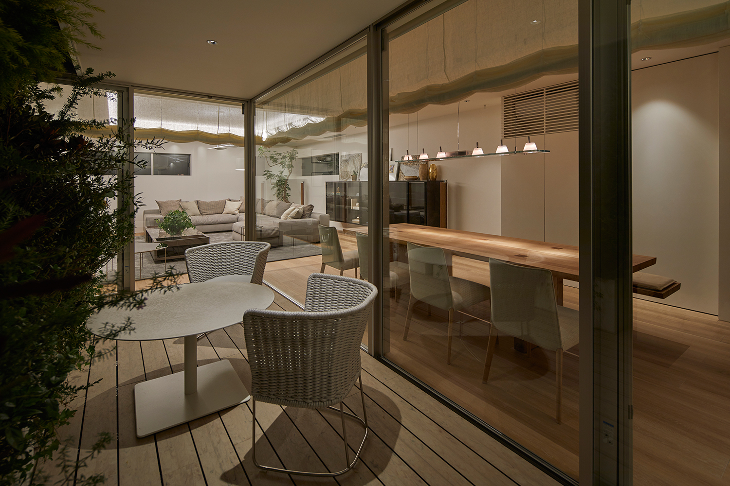 テーブルと椅子が置かれた、LDKとフラットに繋がるウッドデッキのバルコニー 注文住宅・デザイン住宅建築実例_『CASE632 H邸（社長の邸宅）』_テラス・バルコニー