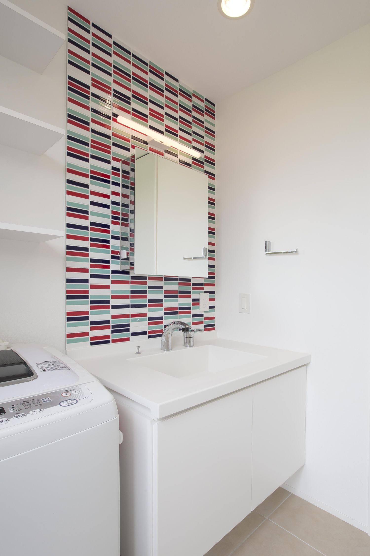 カラフルなタイル壁がある白い洗面台・デザイン住宅