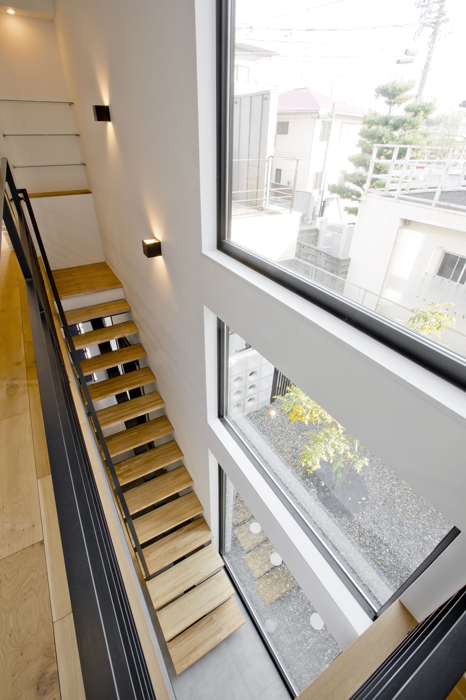 天井近くまで窓を取り付けた木のスケルトン階段・デザイン住宅