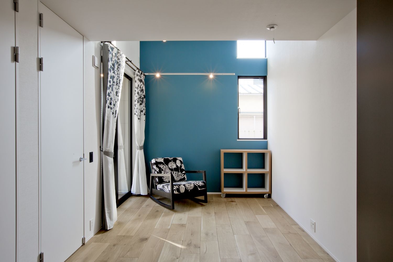 青いアクセントクロスを取り付けたロフト付きの個室・デザイン住宅