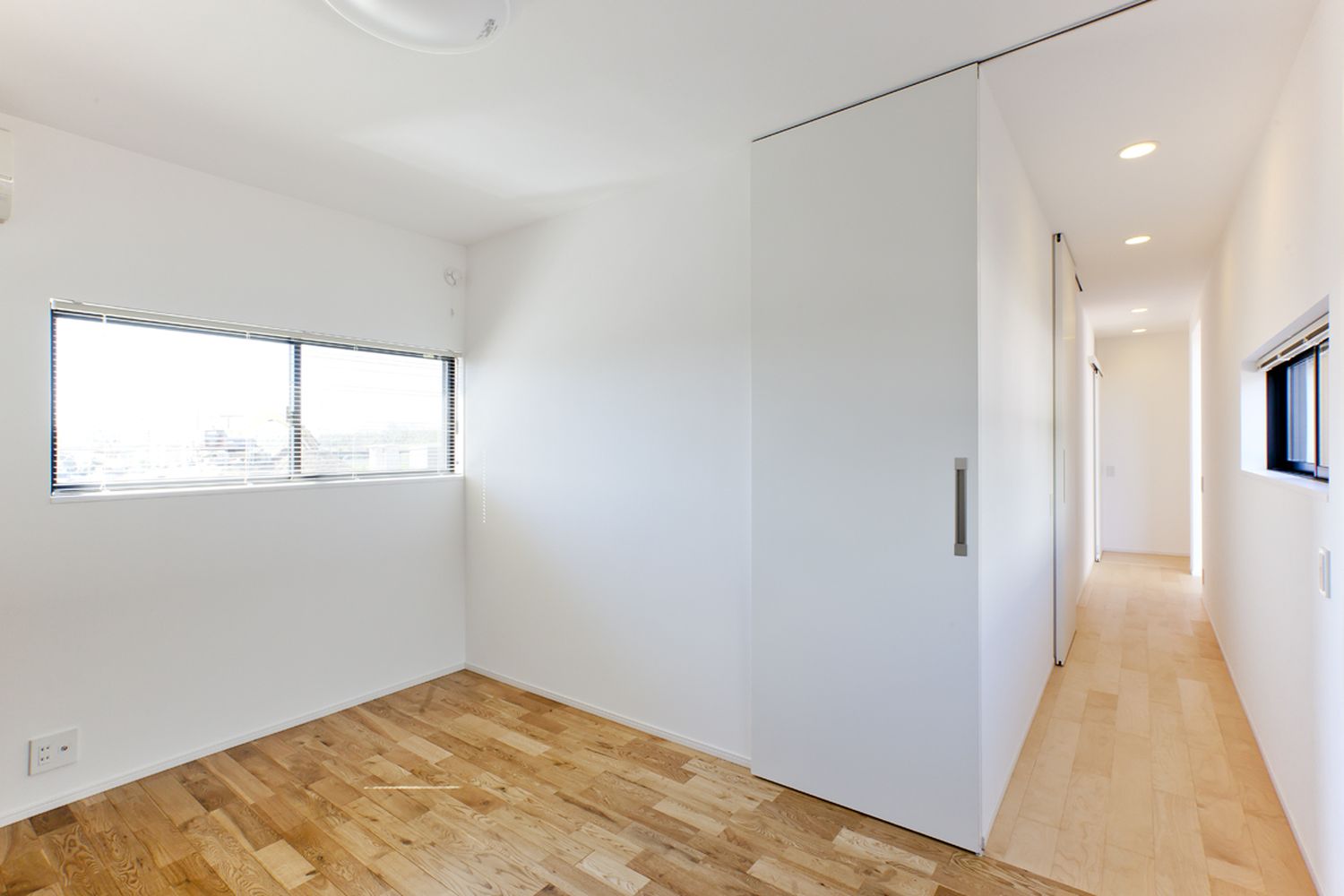 スリット窓にブラインドを取り付けたプライバシー性の高いシンプルな廊下・デザイン住宅