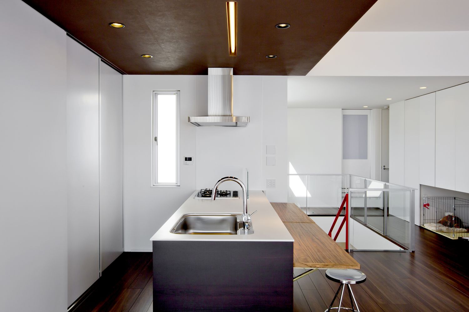 扉付きのカップボードがある木目の下がり天井のキッチン・デザイン住宅