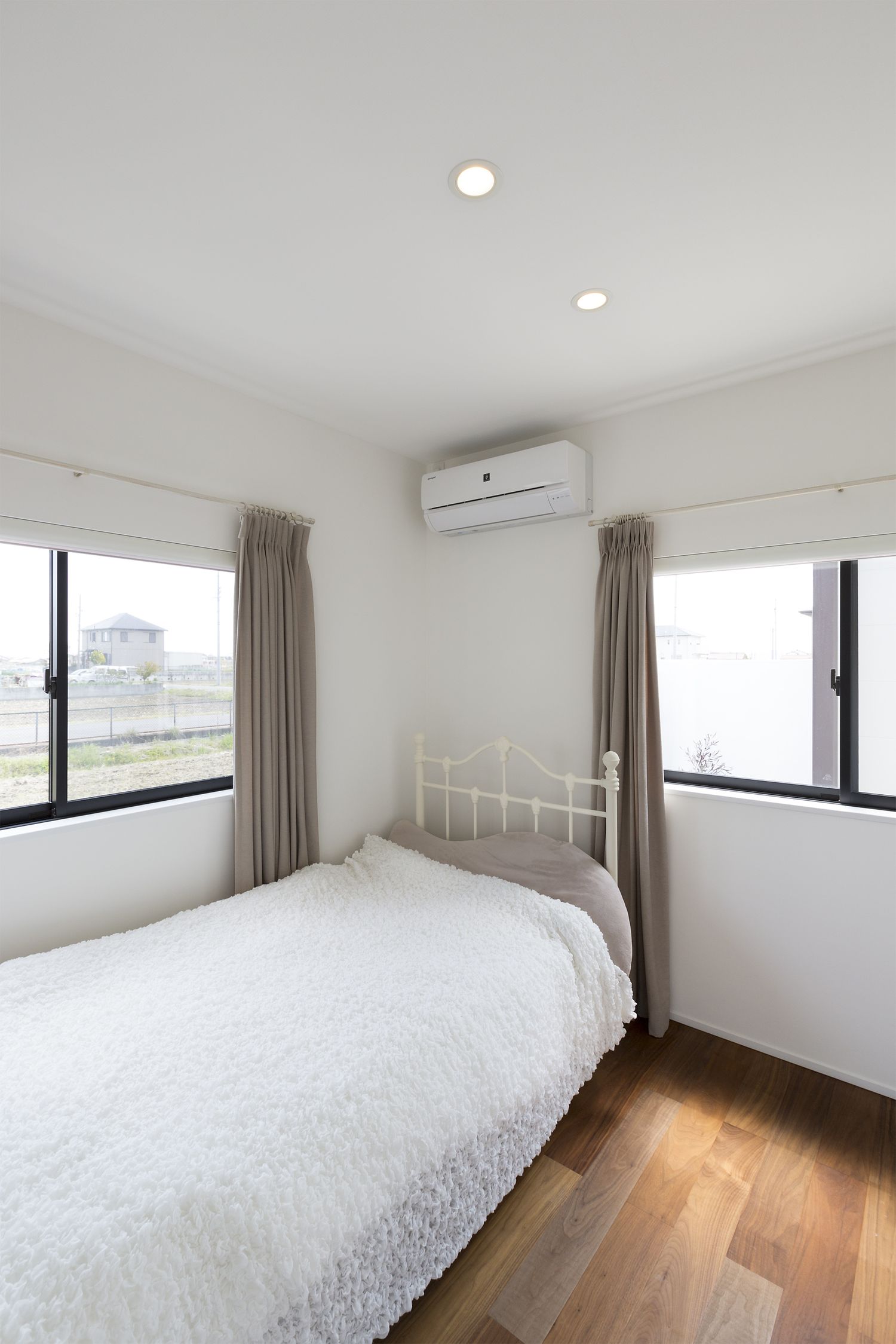 二方向に窓を取り付けた明るい寝室・デザイン住宅