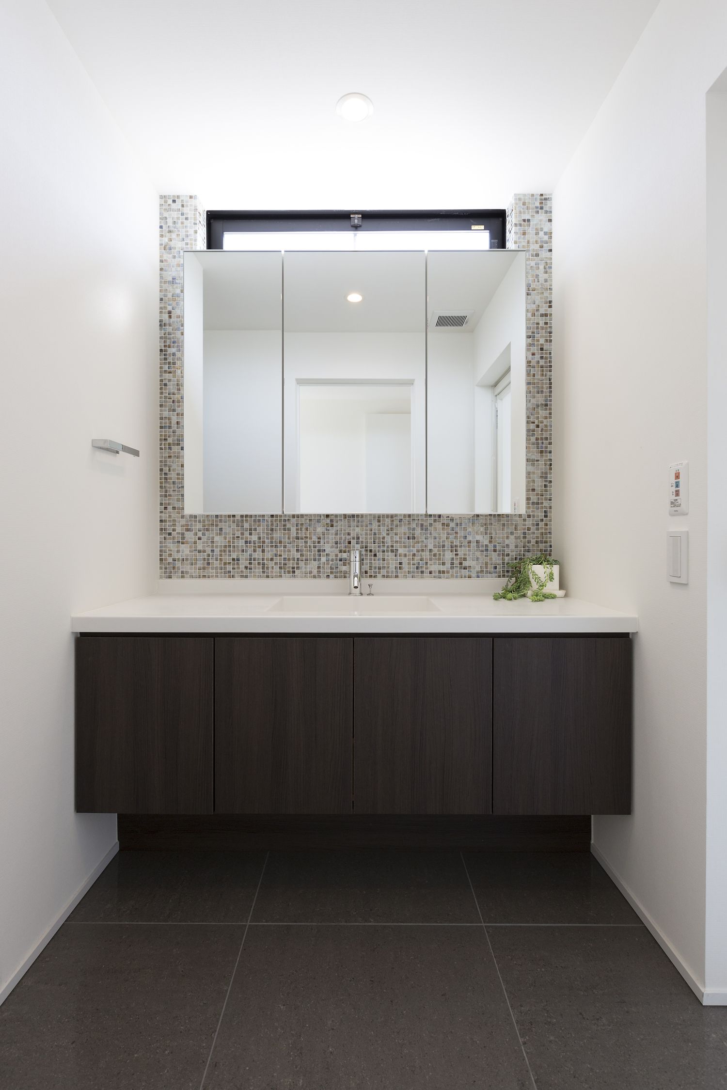 タイルのアクセントウォールがあるスリット窓付きの洗面所・デザイン住宅