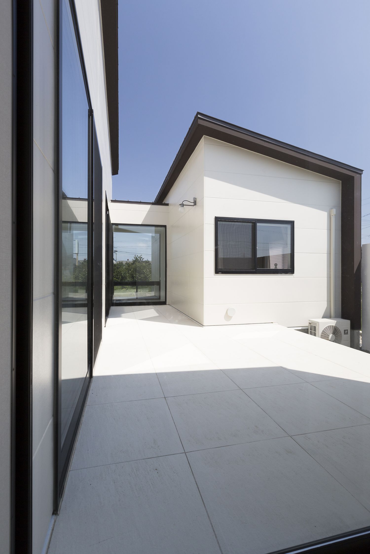 大きな窓に面したタイルの中庭・デザイン住宅