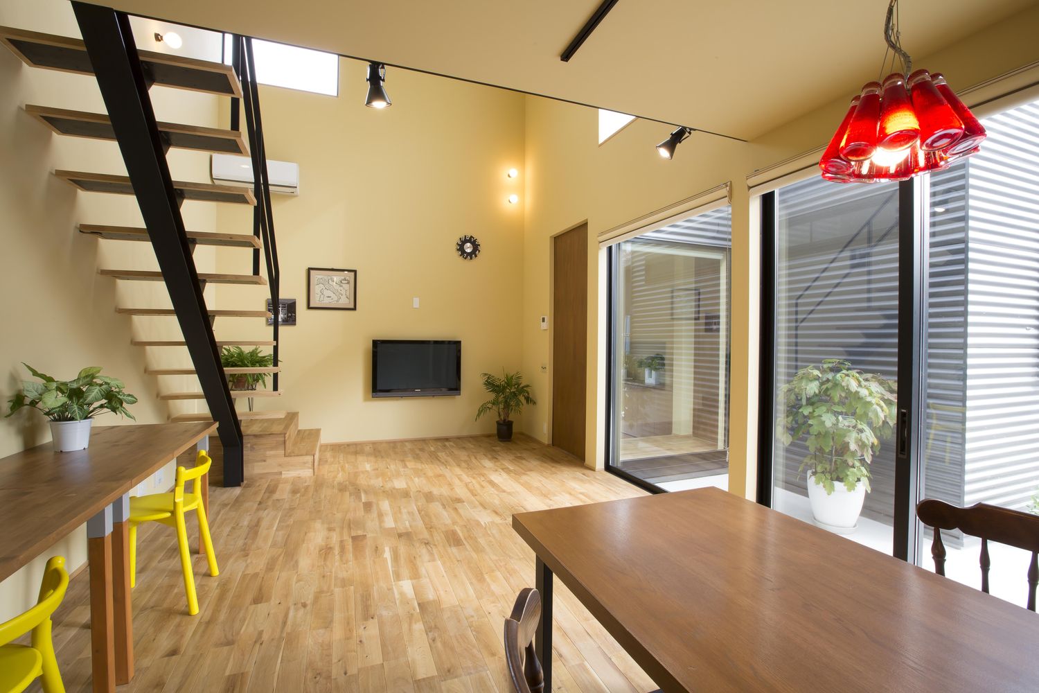 吹き抜けと、テラスに面した大きな窓があるLDK・デザイン住宅