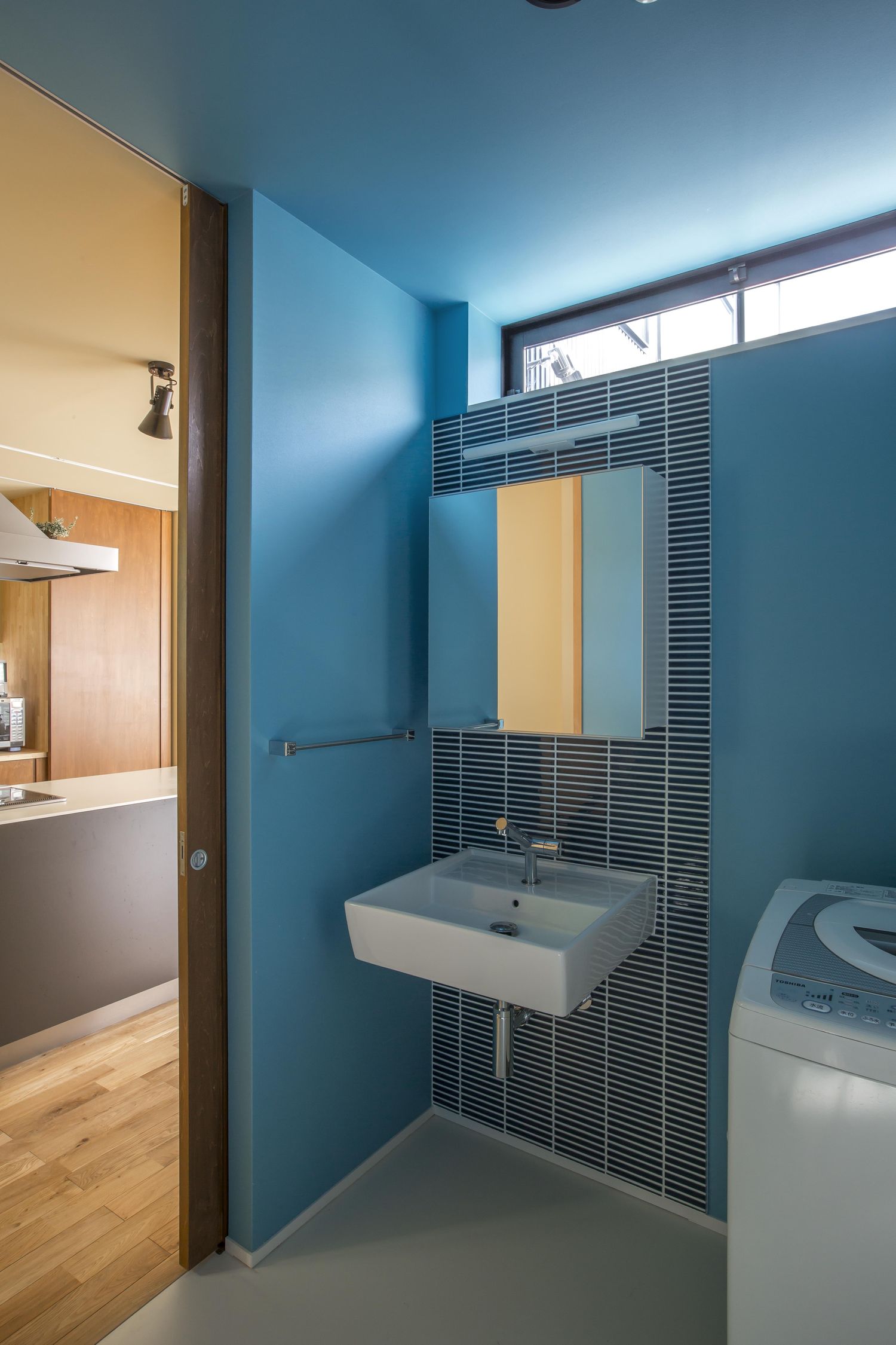 青いクロスでまとめたおしゃれな洗面所・デザイン住宅