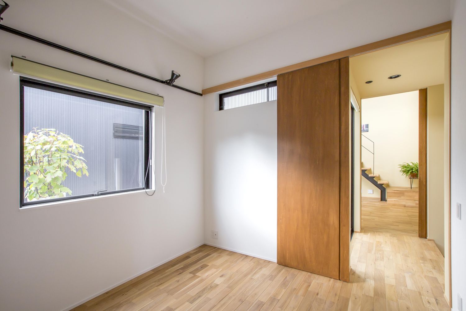 窓の上に間接照明を取り付けた引き戸の寝室・デザイン住宅