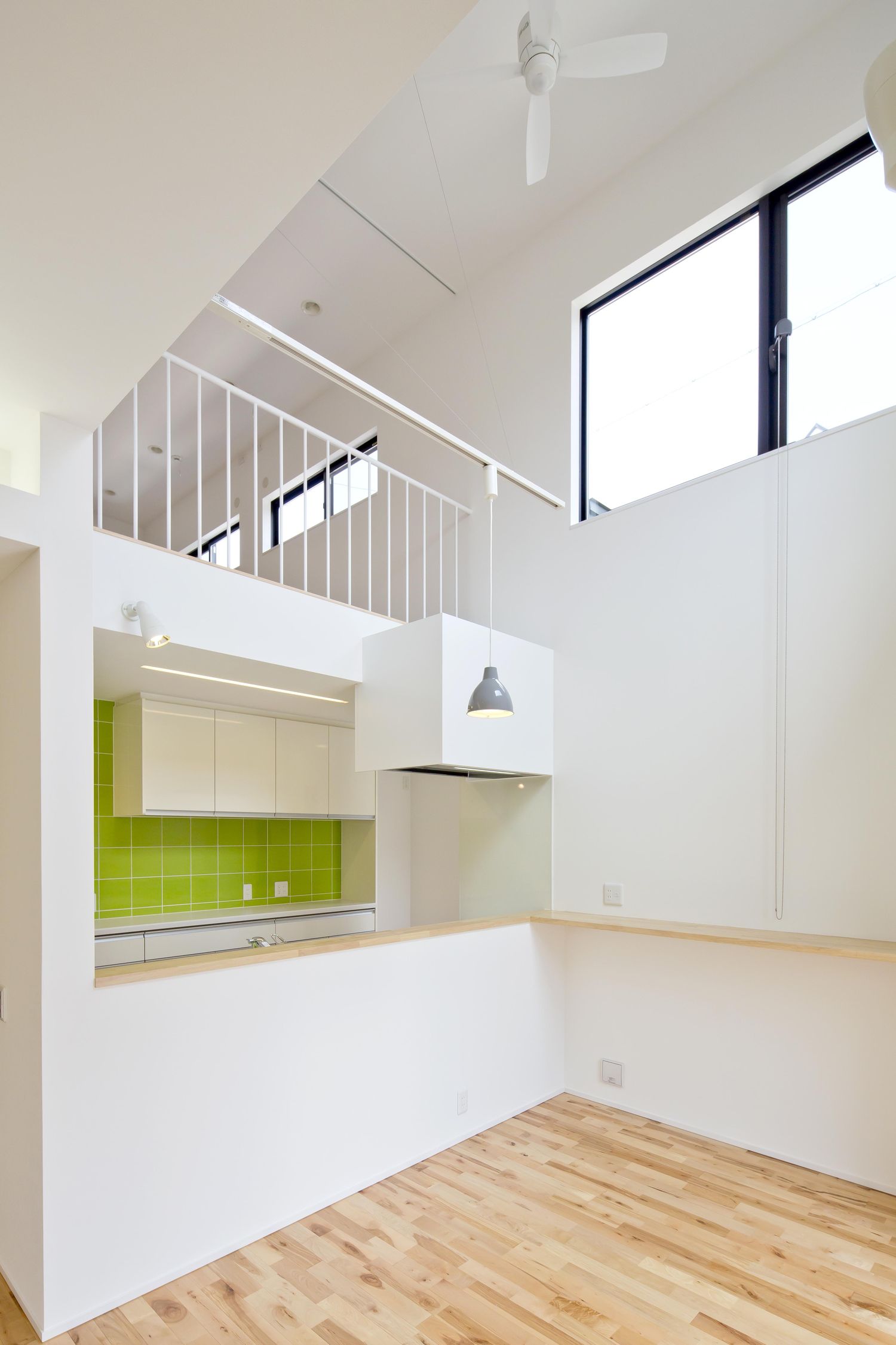 半個室の対面キッチンがある吹き抜けのLDK・デザイン住宅