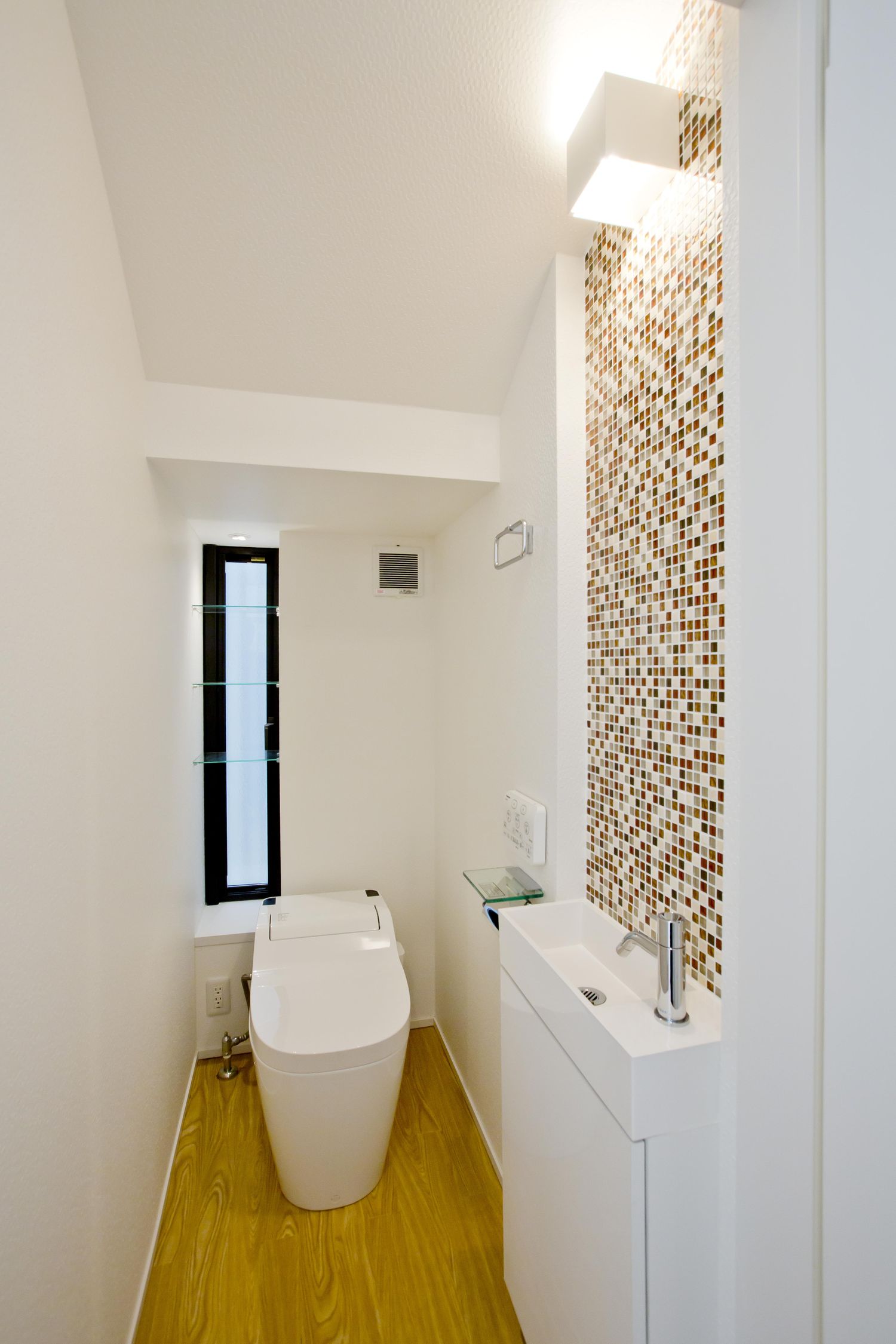 タイルのアクセントウォール付きの薄型手洗いがあるトイレ・デザイン住宅