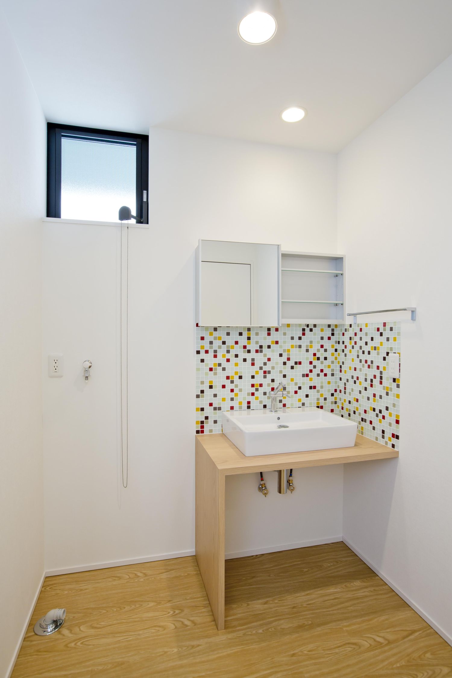 手元にタイルのアクセントを取り付けた部屋の角にある手洗いカウンター・デザイン住宅