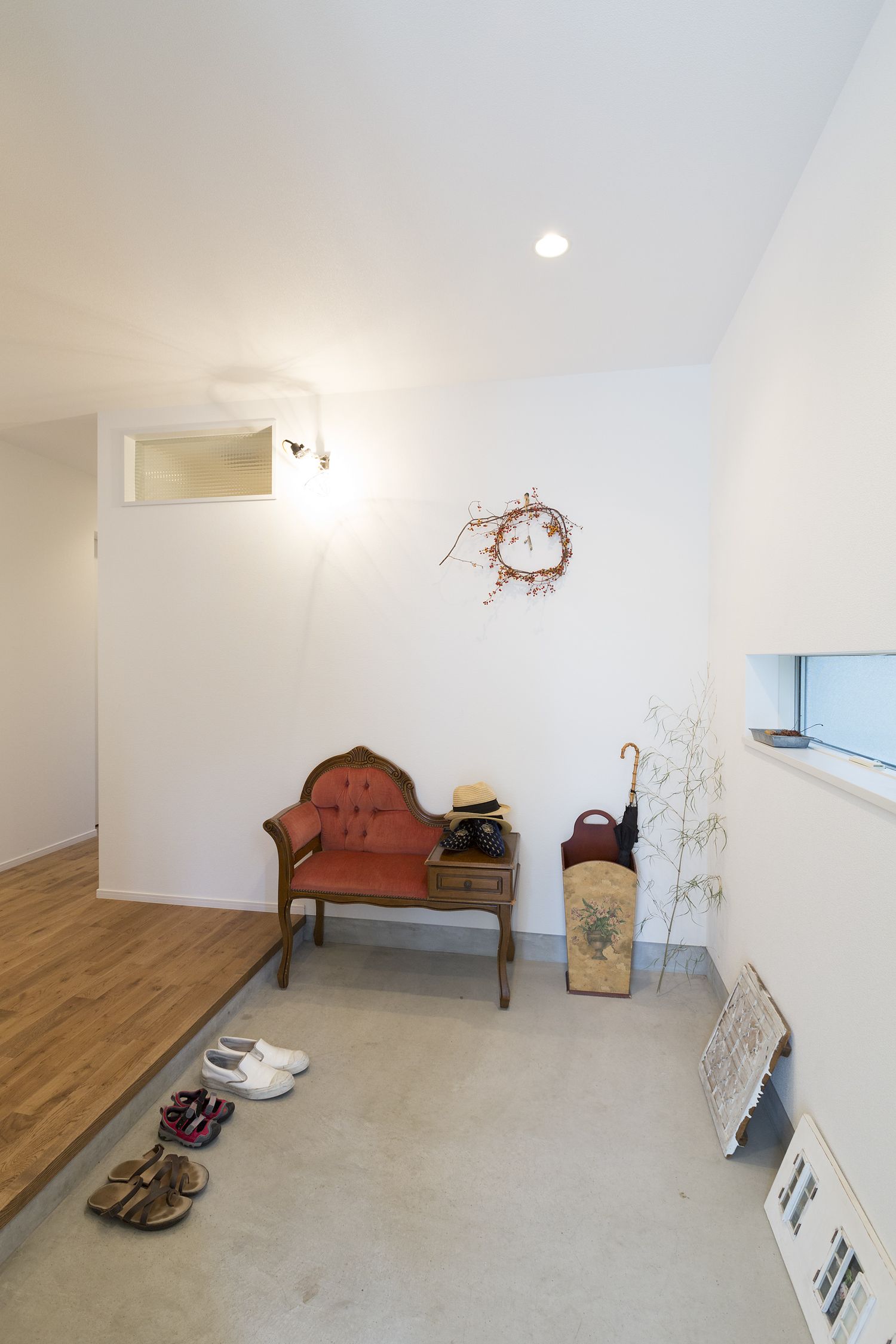 アンティーク家具を置いたモルタル玄関・デザイン住宅