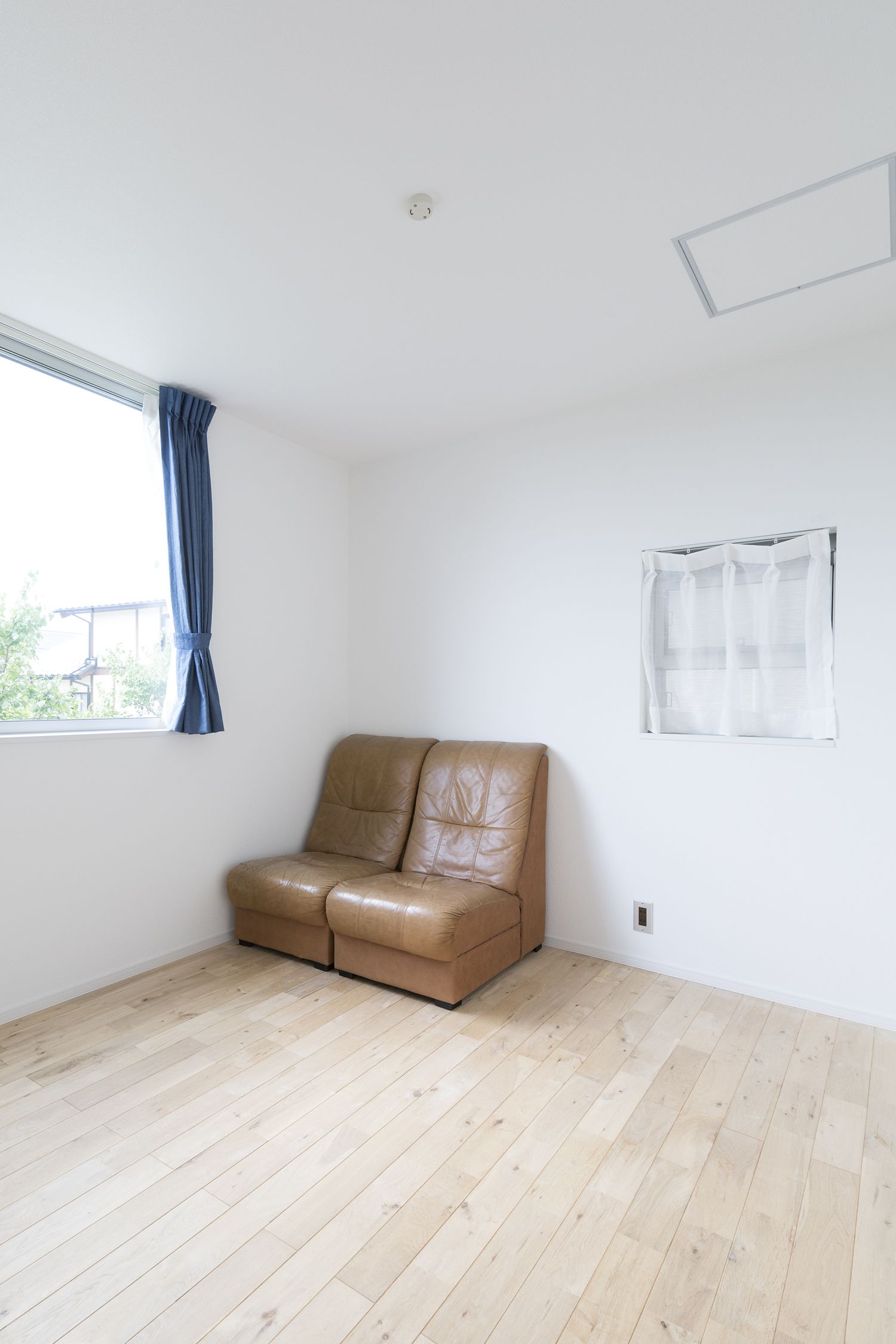 茶色のレザーのソファーを置いたシンプルな空間・デザイン住宅