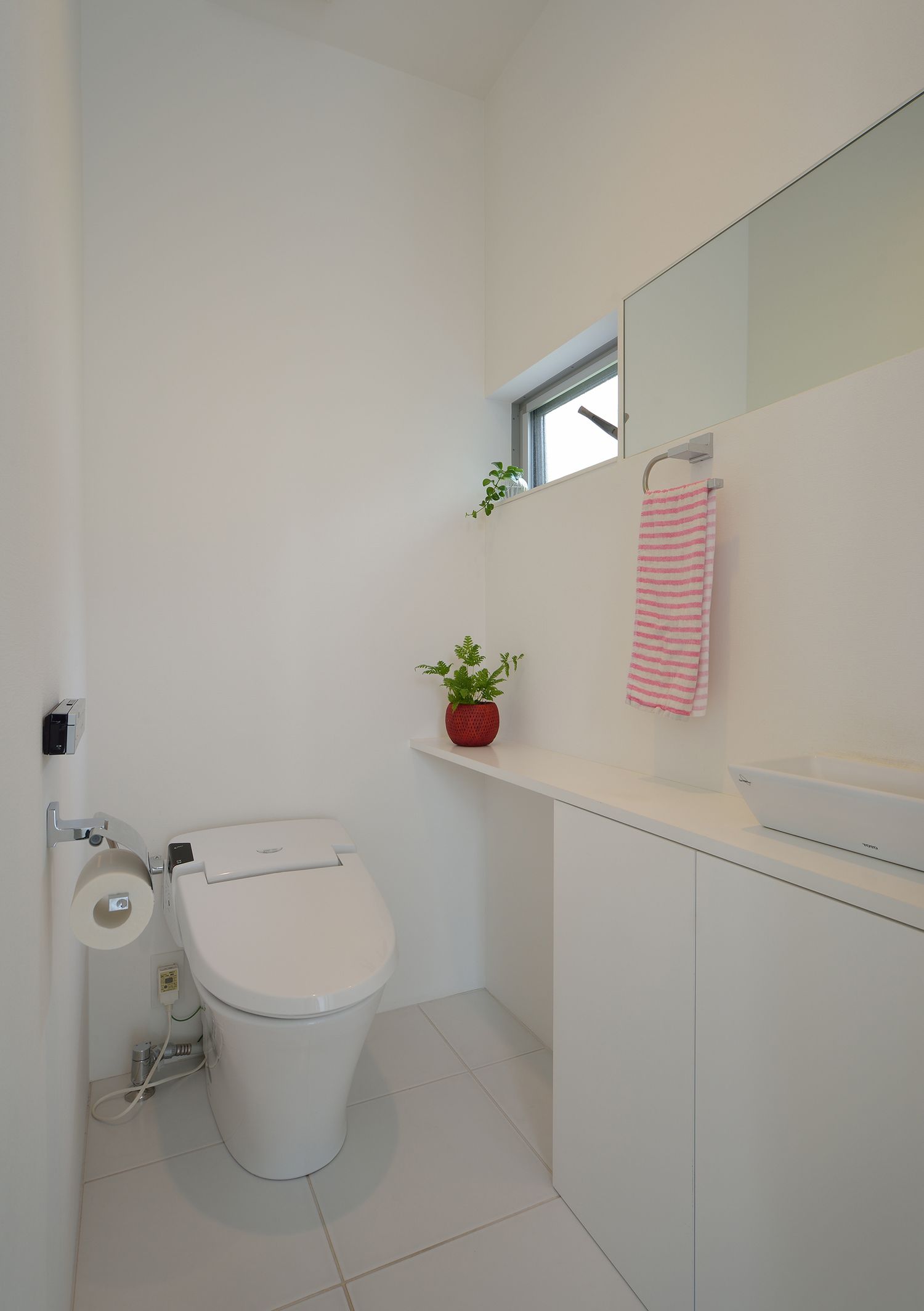 薄型手洗いや小さい窓を取り付けたコンパクトなトイレ・デザイン住宅