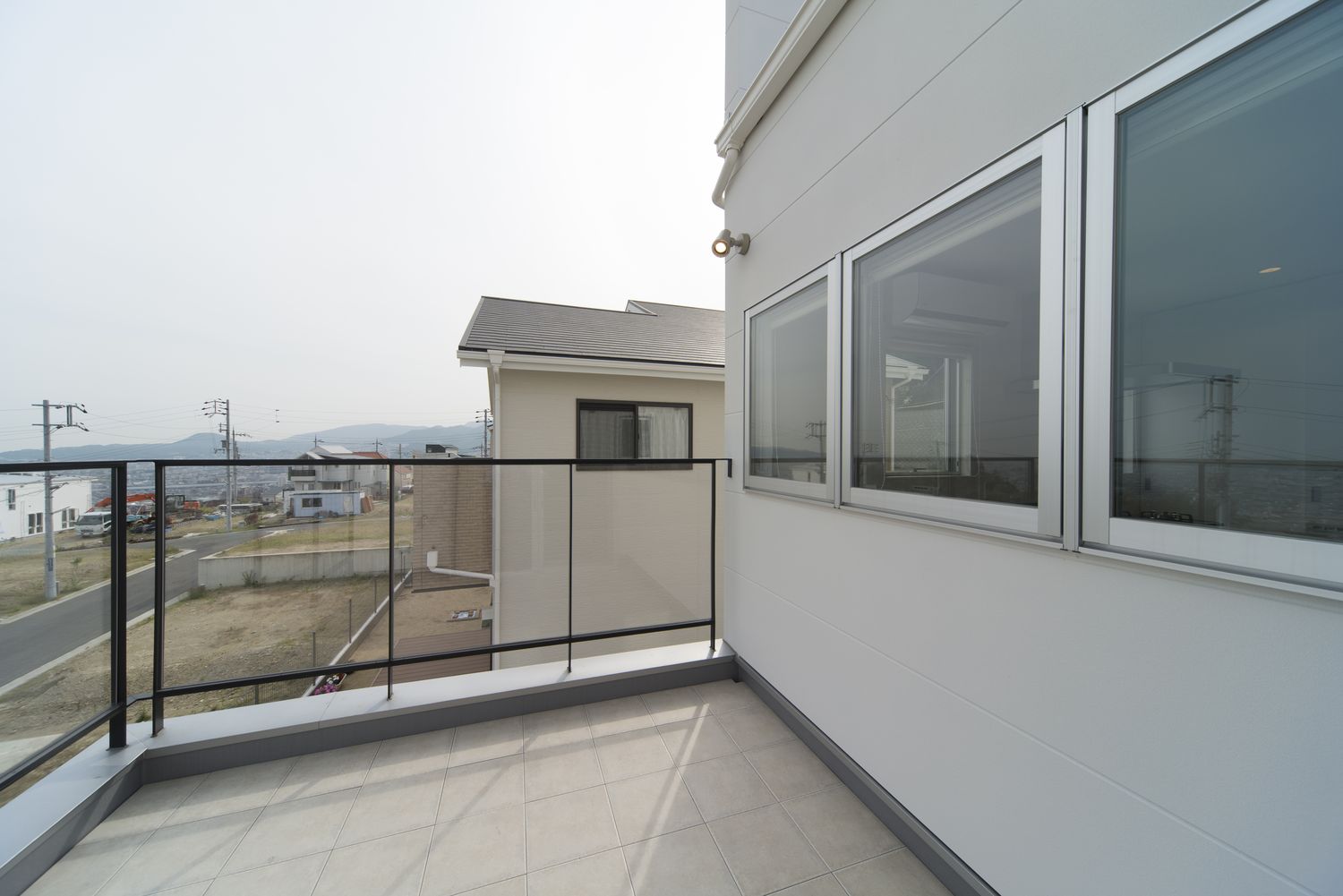 細い柵を取り付けた開放的なバルコニー・デザイン住宅