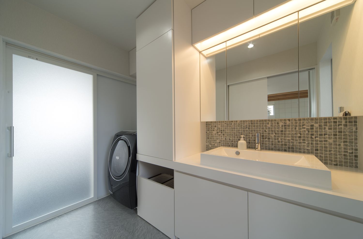 タイルのアクセントウォールがあるシンプルで清潔感のある洗面所・デザイン住宅