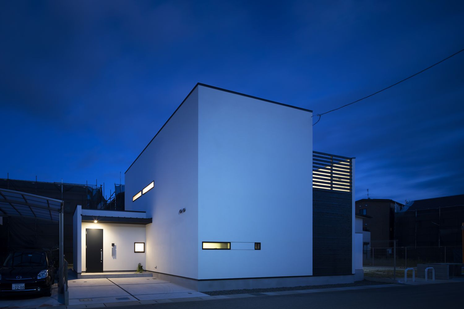 軒天井に照明を取り付けた黒い扉の玄関・デザイン住宅