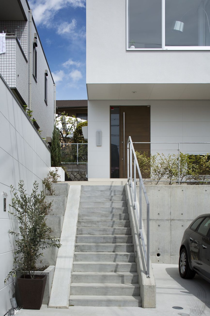 コンクリートの階段のアプローチがある高台の住まい・デザイン住宅