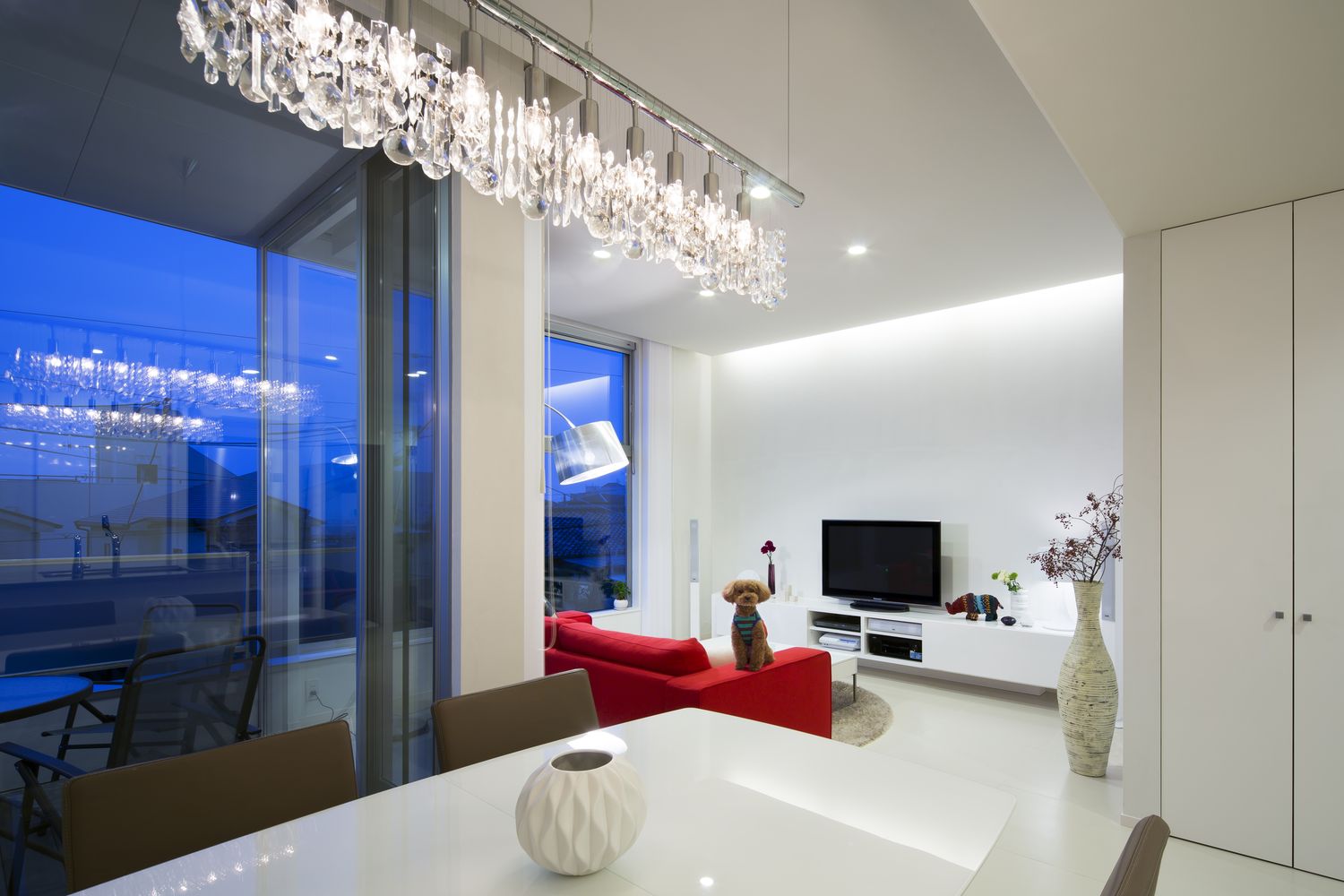 おしゃれなシャンデリアが取り付けられた高級感のある白いLDK・デザイン住宅