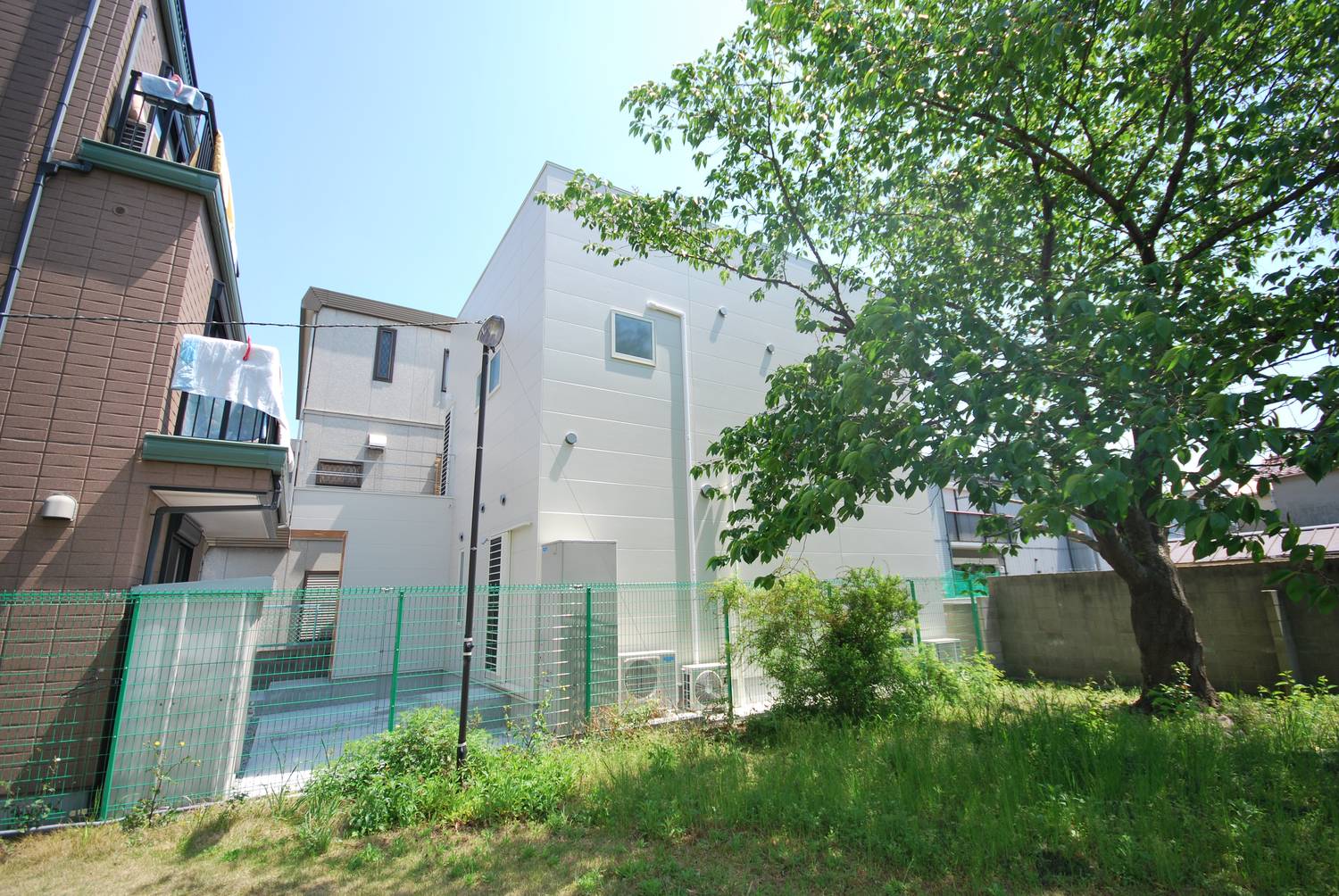 緑豊かな環境のそばに建つ白い外壁の家・デザイン住宅