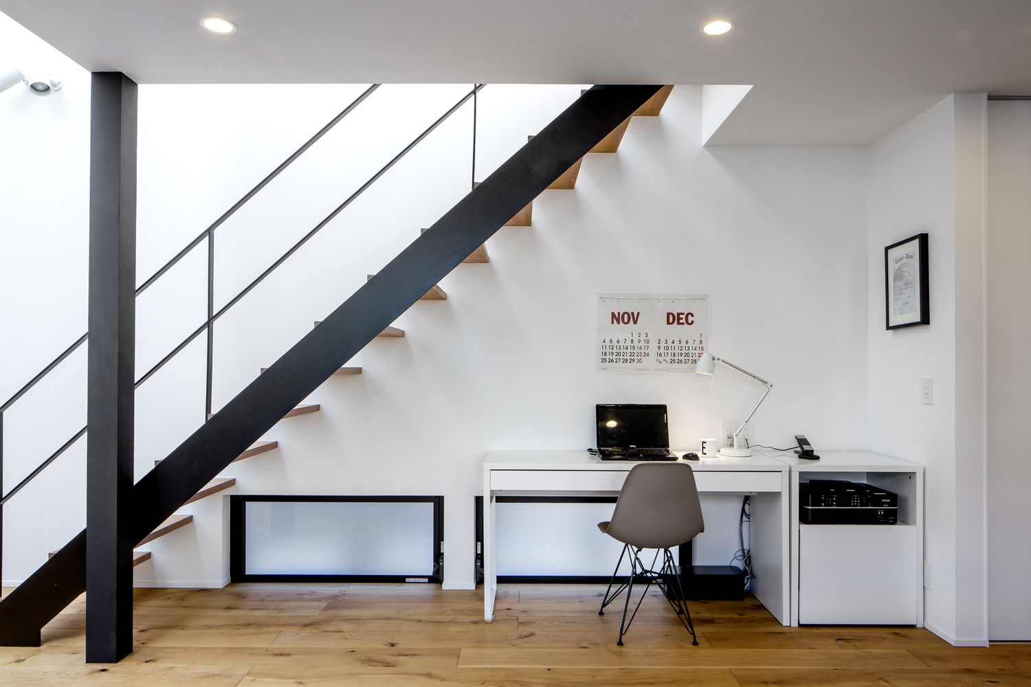木のスケルトン階段の下にデスクをおいたワークスペースがあるLDK・デザイン住宅