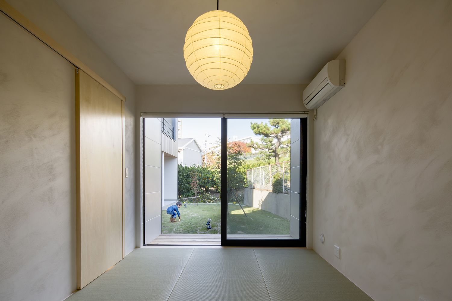庭に面した大きな窓や丸い間接照明があるモダンな和室・デザイン住宅