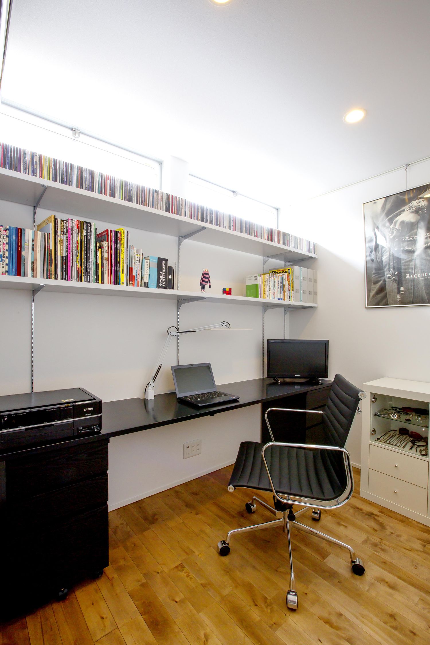 壁付けの本棚と壁付けデスクがあるコンパクトな書斎・デザイン住宅