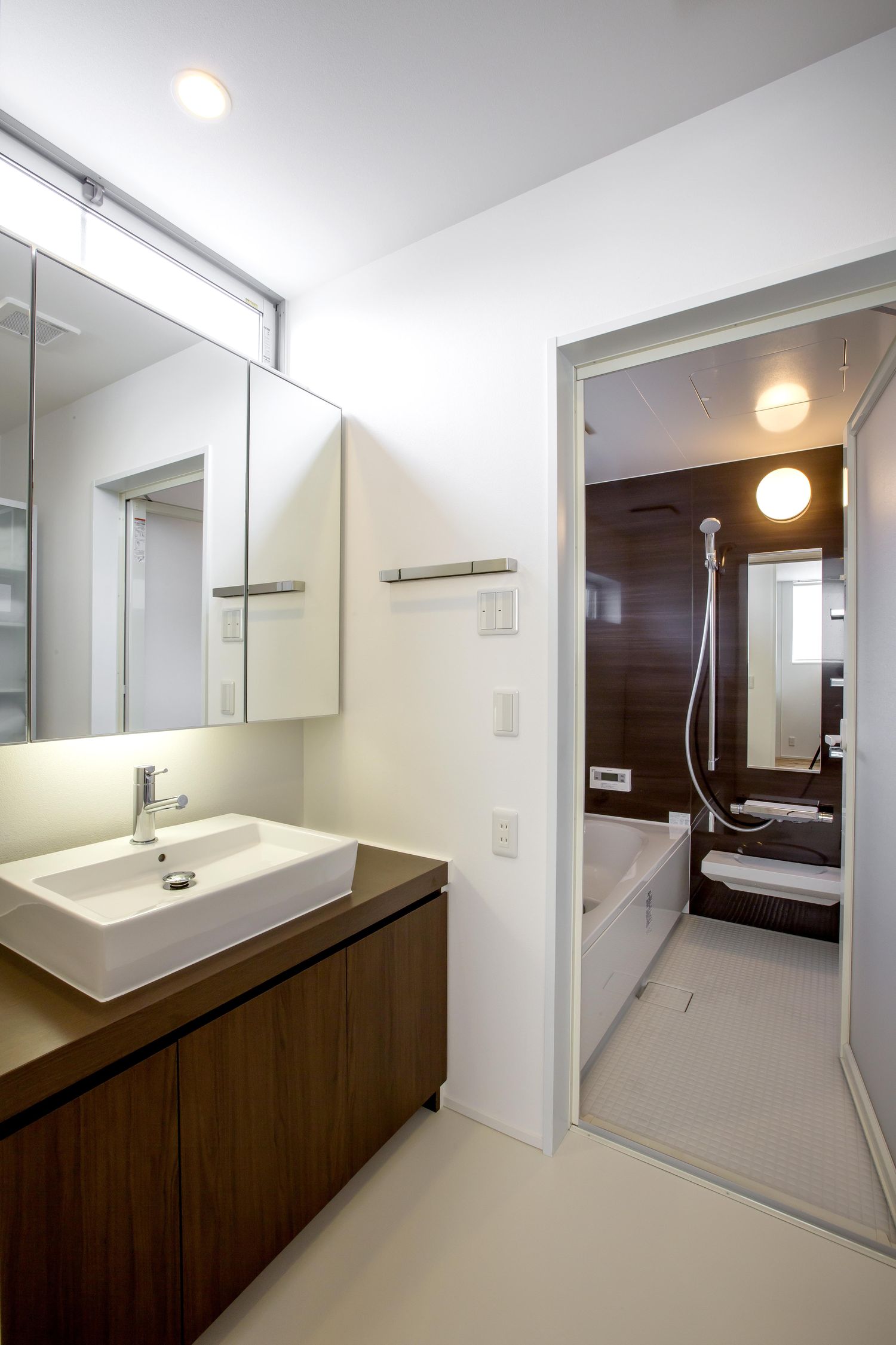 コンパクトな洗面所の奥にあるユニットバスの浴室・デザイン住宅