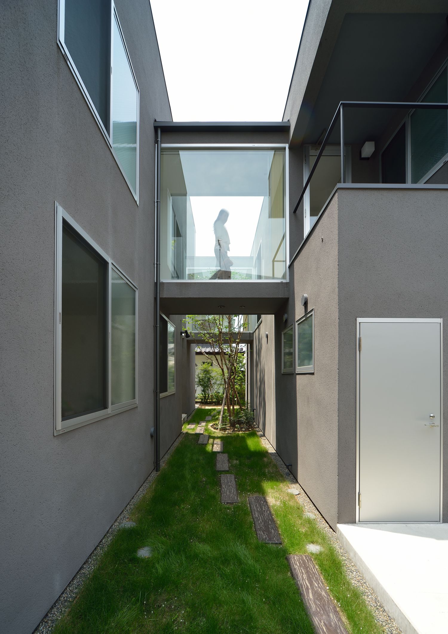 中庭にガラス窓付きの渡り廊下があるおしゃれな家・デザイン住宅