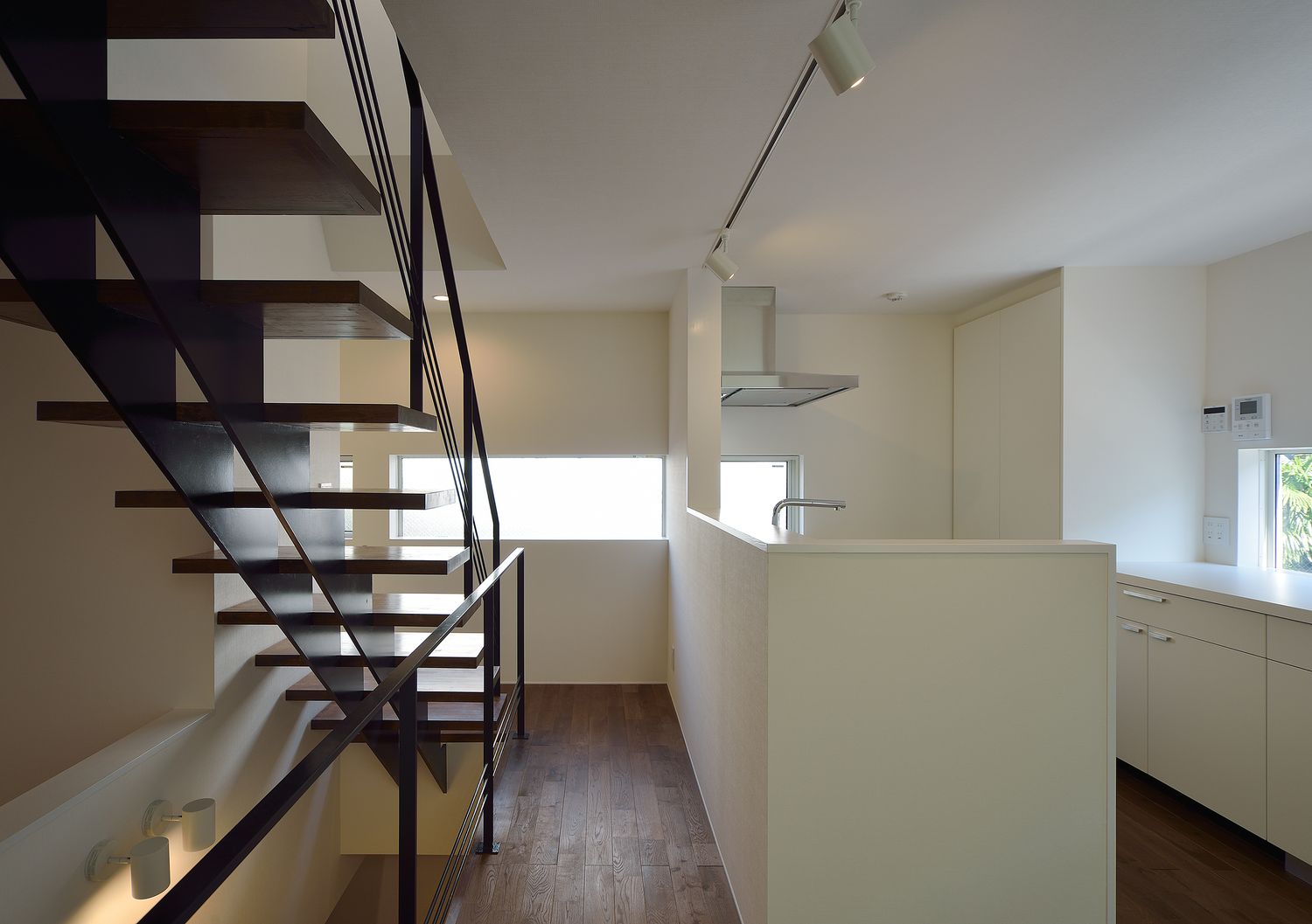 横長のスリット窓から光が入る白を基調としたキッチン・デザイン住宅