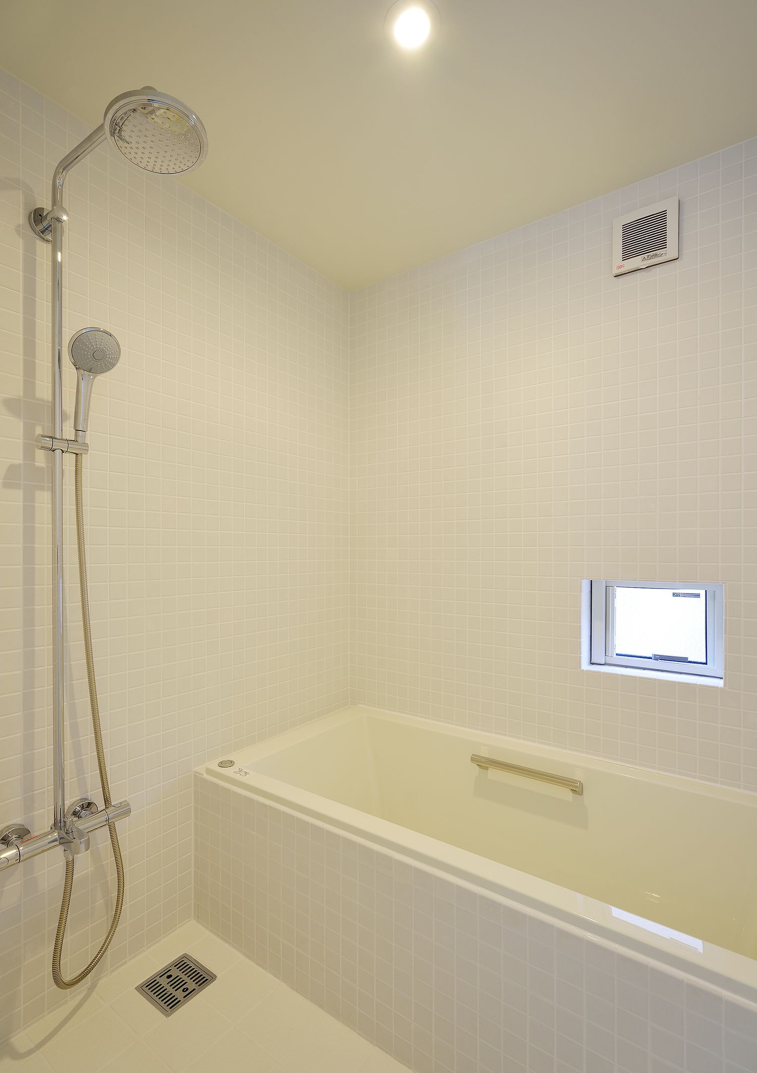 小さな窓を取り付けたシンプルな白い浴室・デザイン住宅