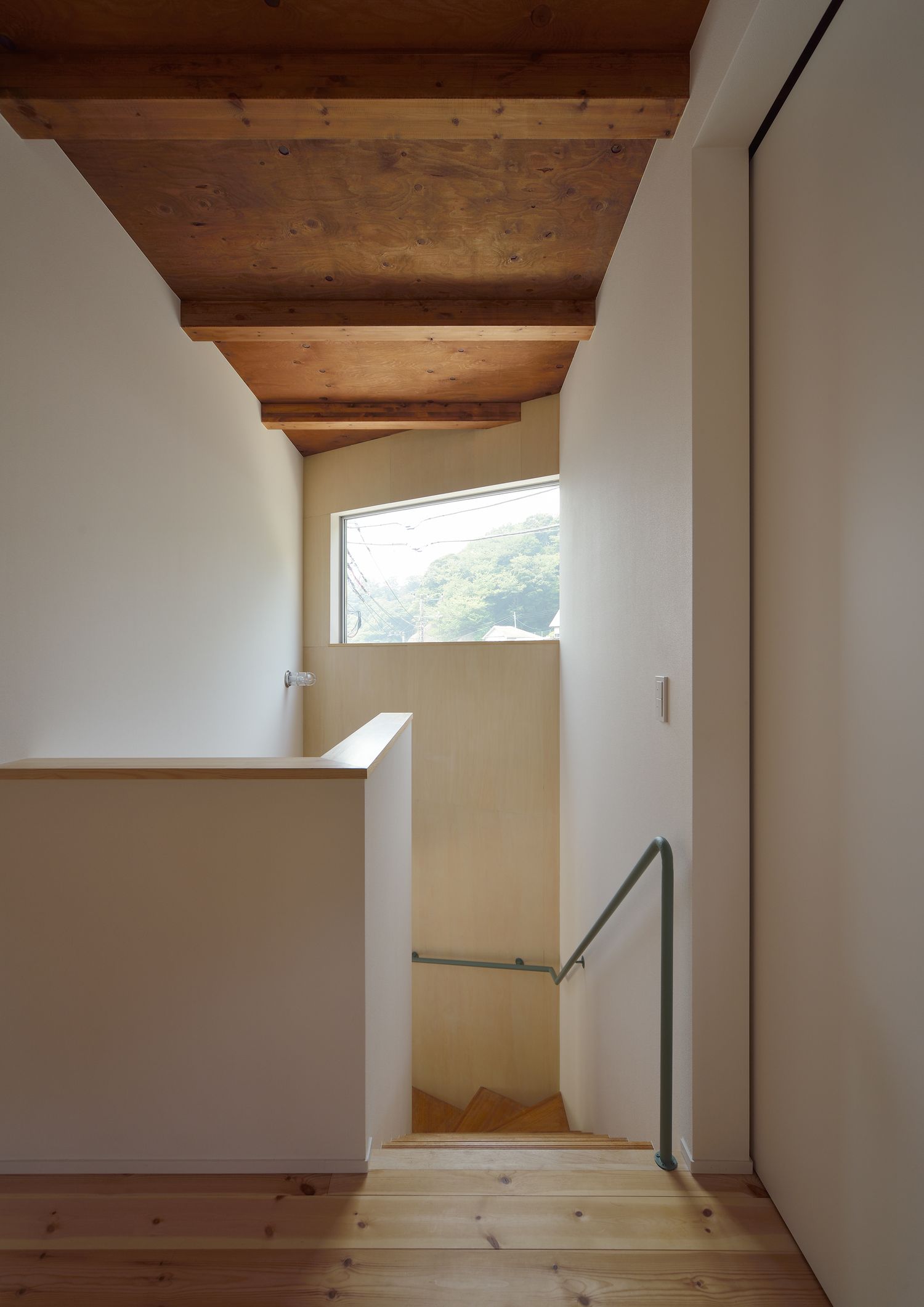 高い位置に窓がある木の天井の階段室・デザイン住宅