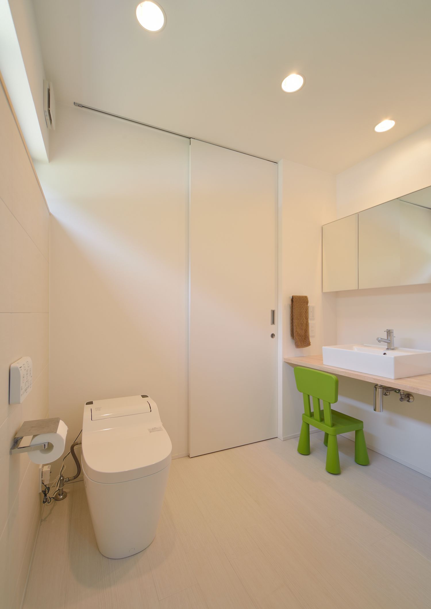 椅子を置いた洗面台とトイレが一体となった空間・デザイン住宅