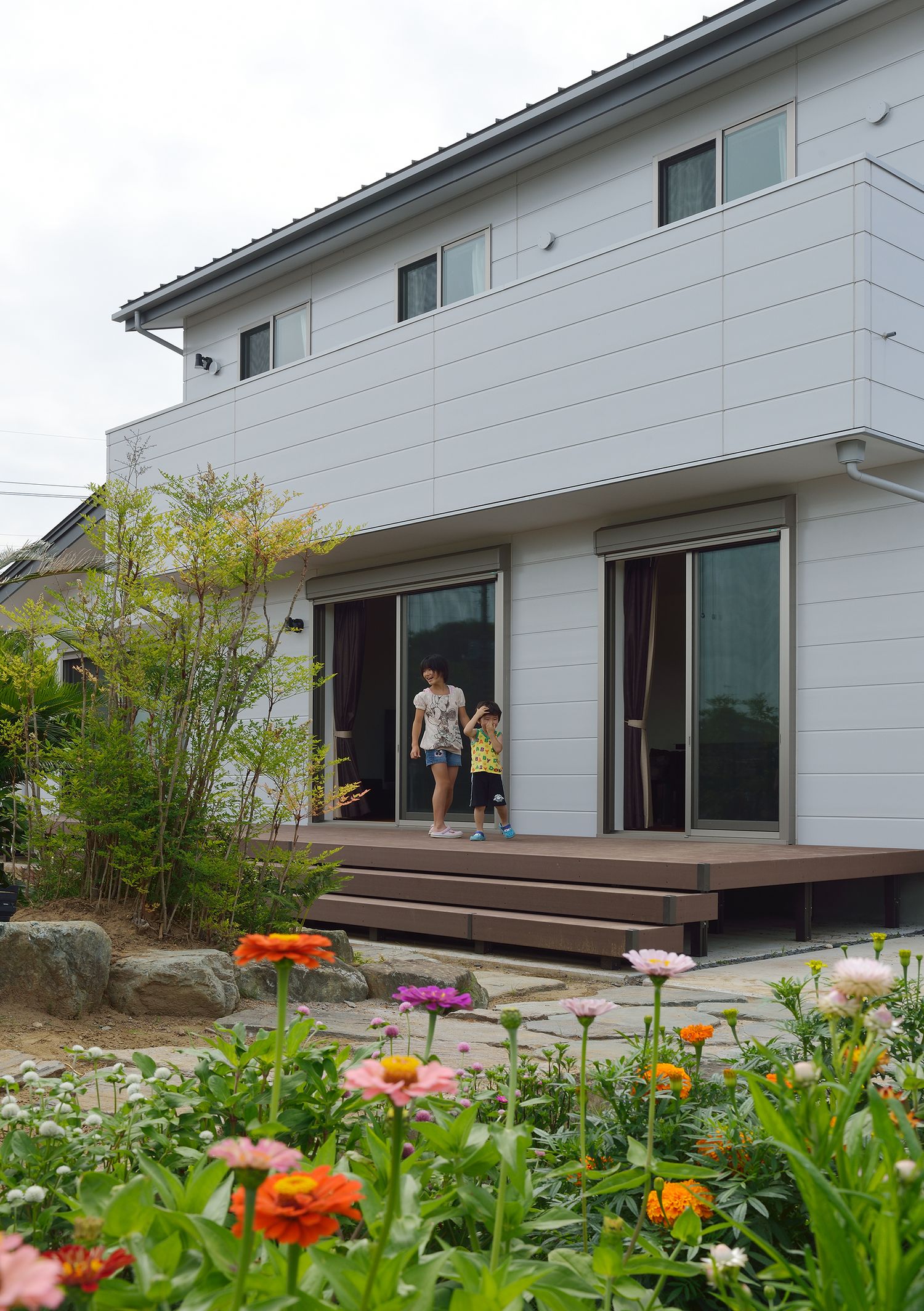 ウッドデッキのテラスや庭がある白い外壁の家・デザイン住宅