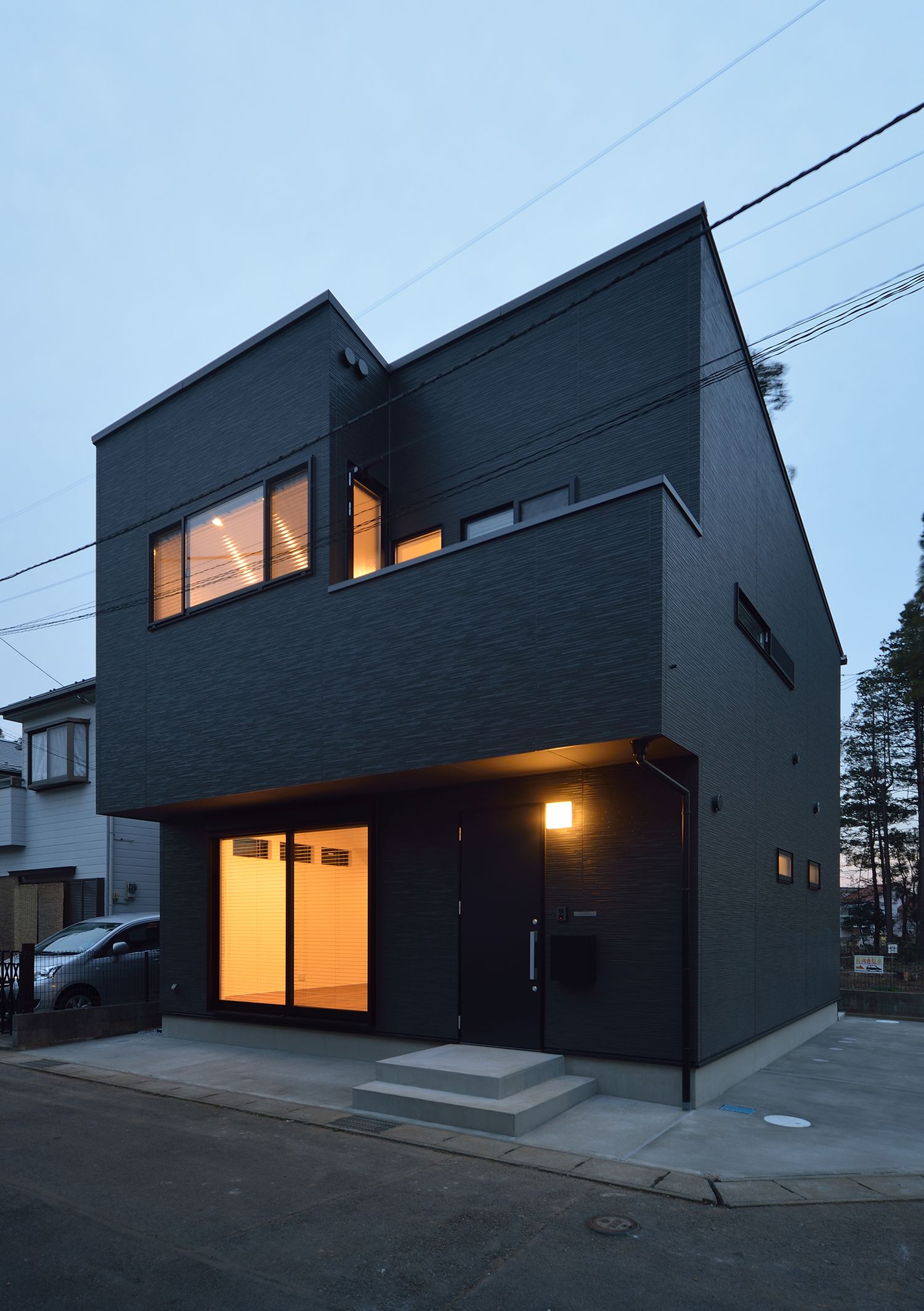 角地に建つシンプルな黒い外壁の家の外観・デザイン住宅