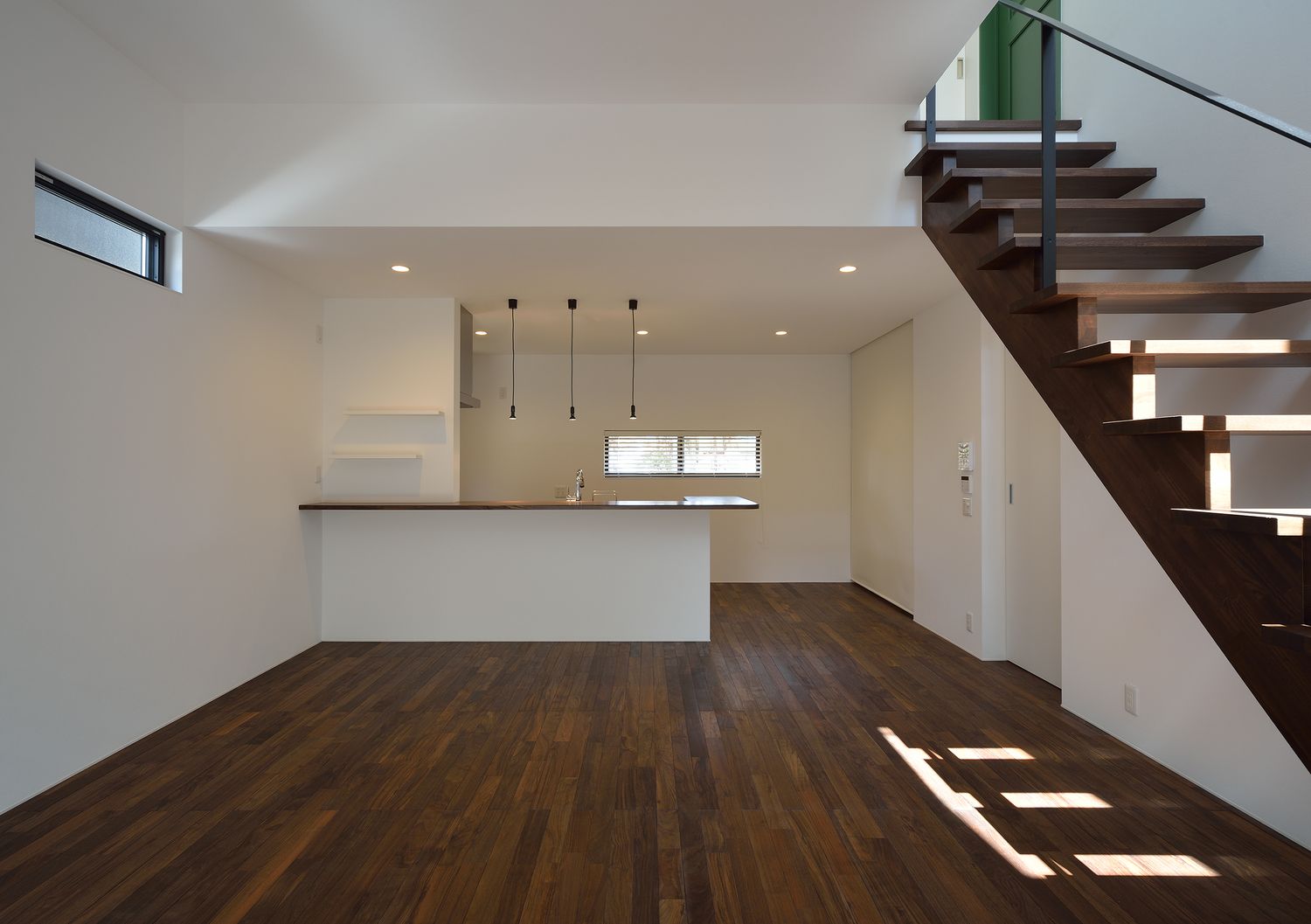 高天井で濃い色のフローリングのLDK・デザイン住宅