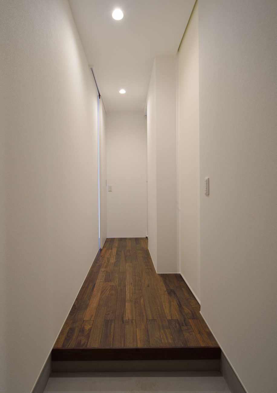 白い壁で木のフローリングのシンプルな廊下・デザイン住宅