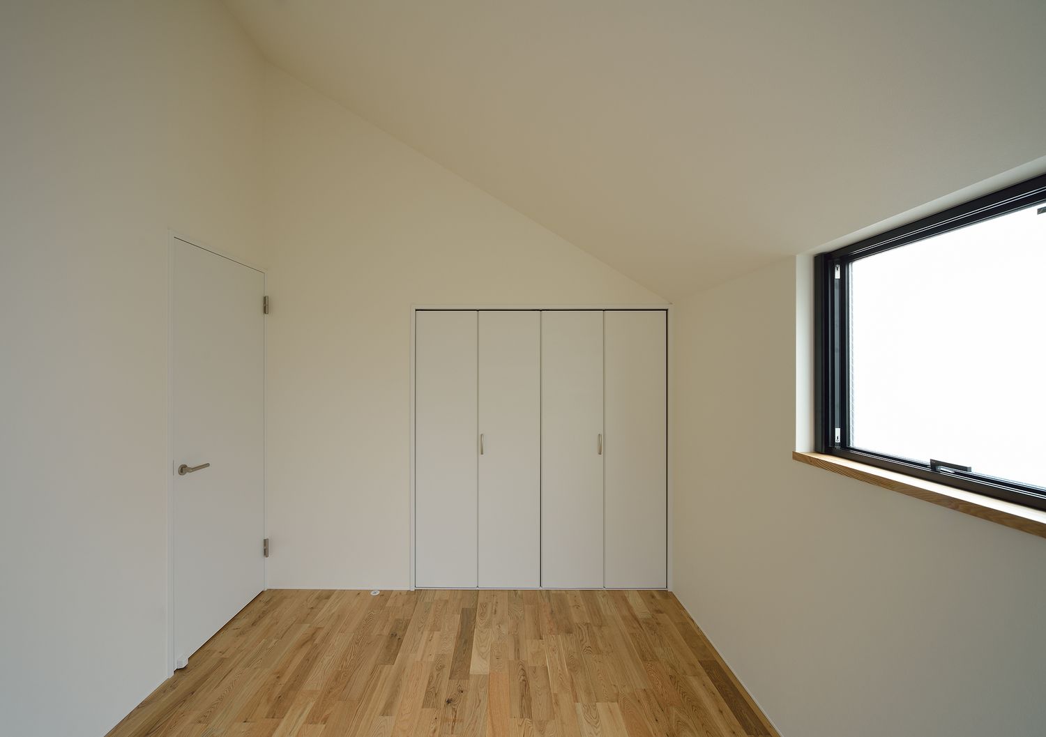 小さな窓を取り付けた母屋下がりのシンプルな寝室・デザイン住宅