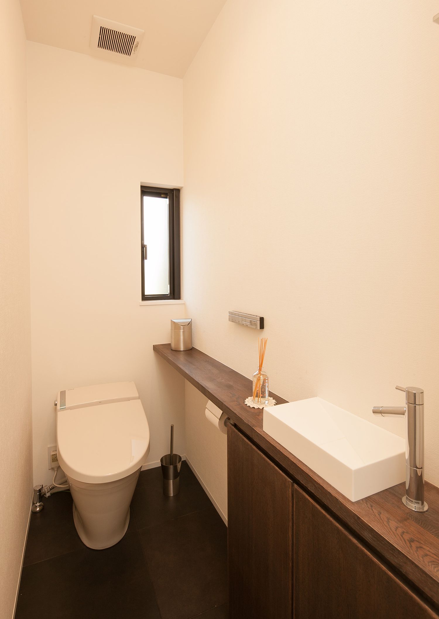 薄型手洗いが取り付けられたシンプルなトイレ・デザイン住宅