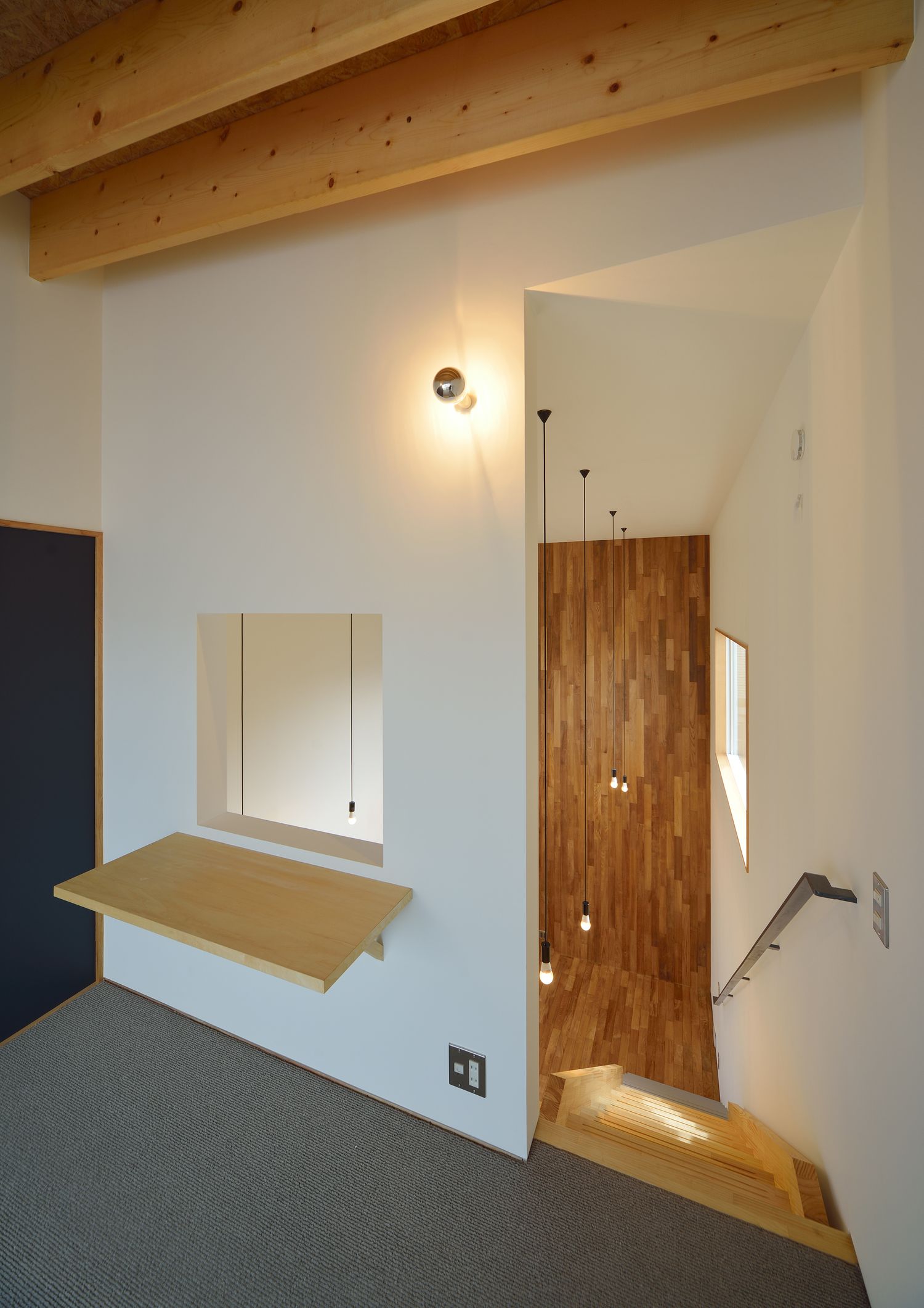 吹き抜けに面した室内窓とデスクが取り付けられた廊下・デザイン住宅