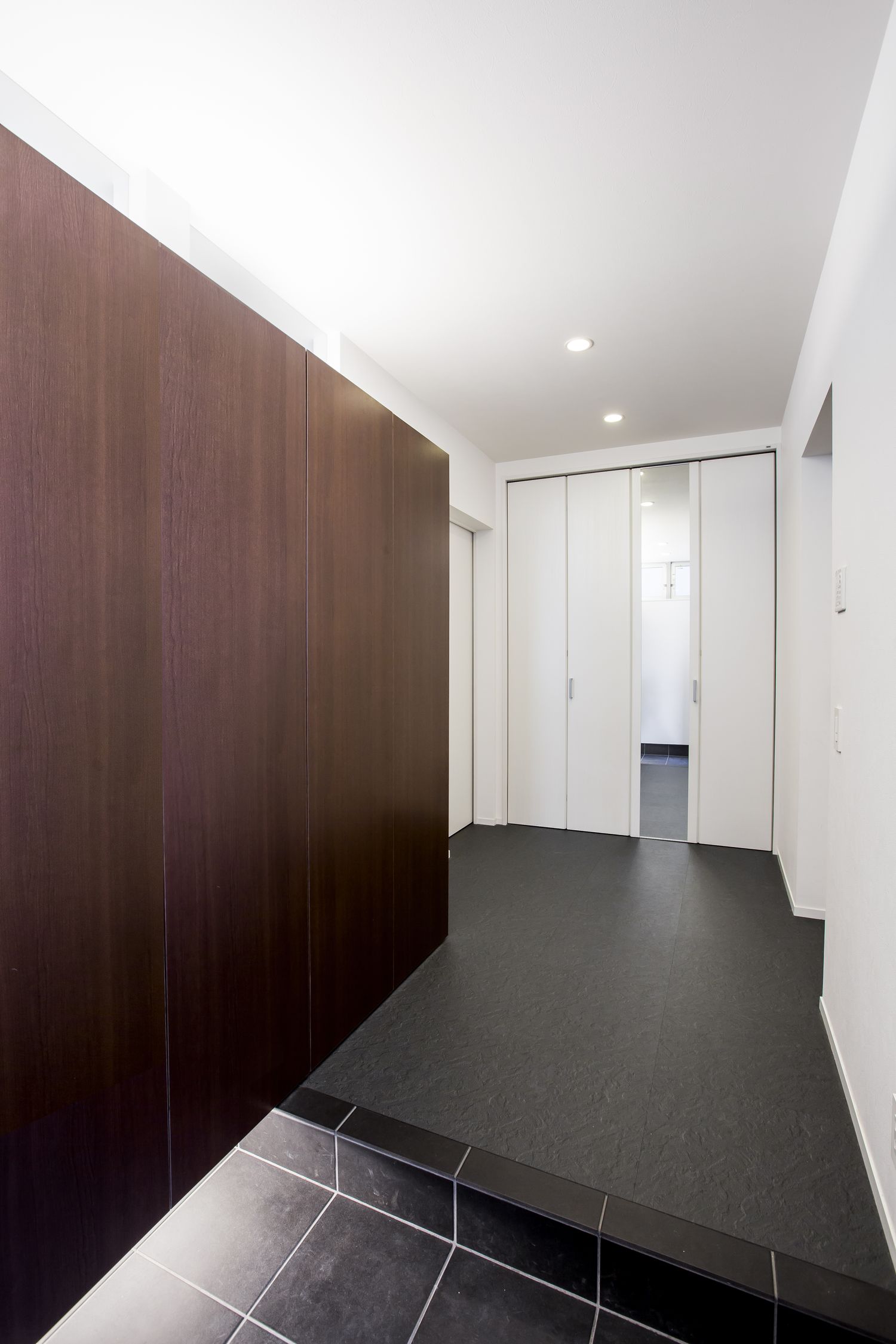 シューズボックスの下に間接照明を取り付けたシンプルな玄関・デザイン住宅