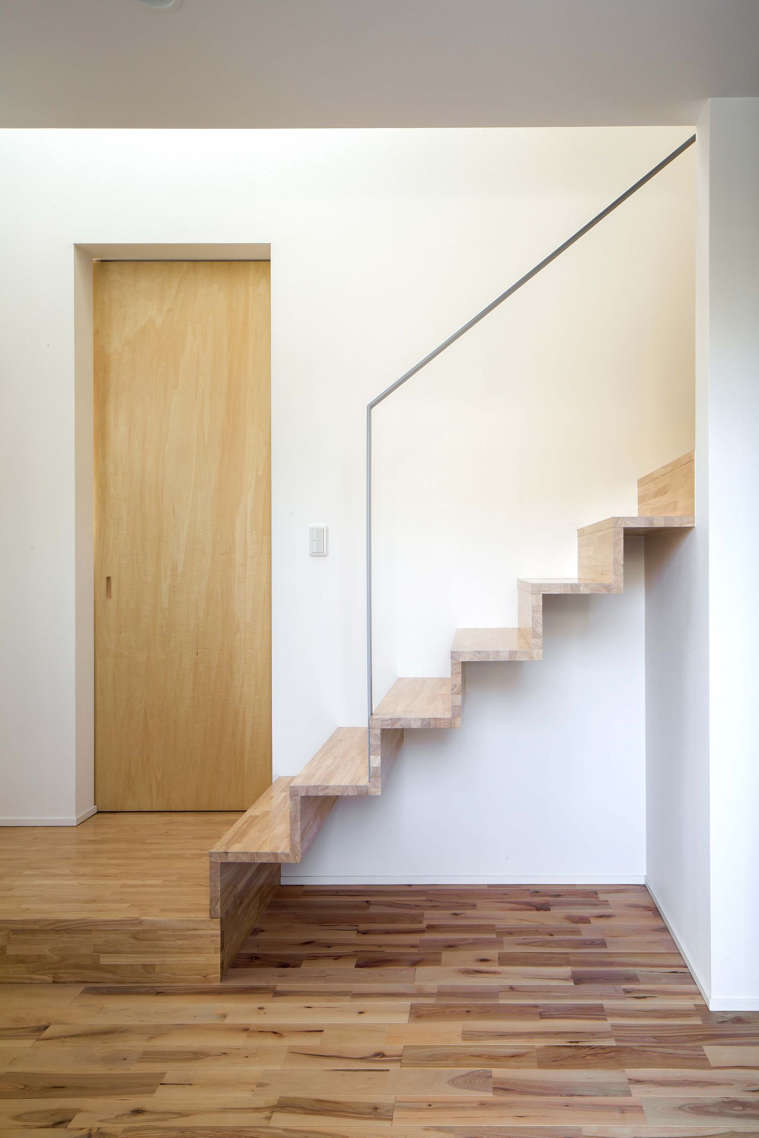 階段下のスペースが空いている木のスケルトン階段・デザイン住宅